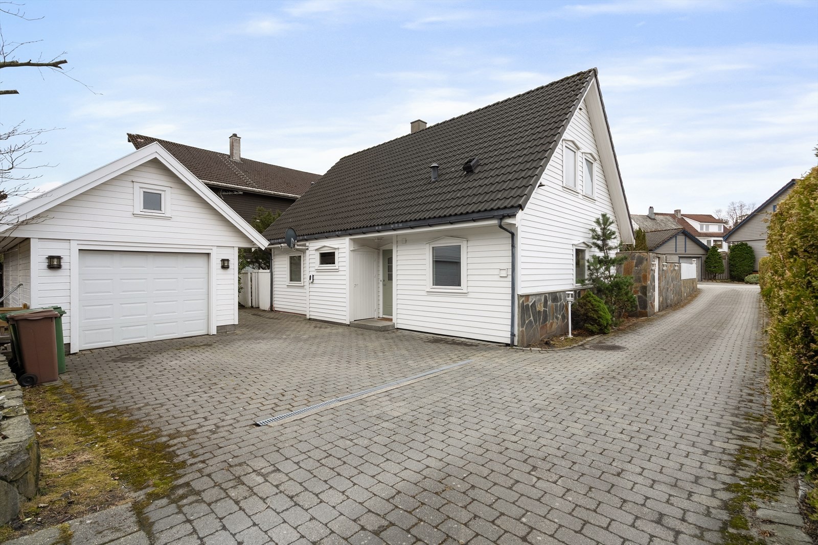 Parkering i garasje med lagringsplass på hems og i steinbelagt gårdsrom. Galleribilde
