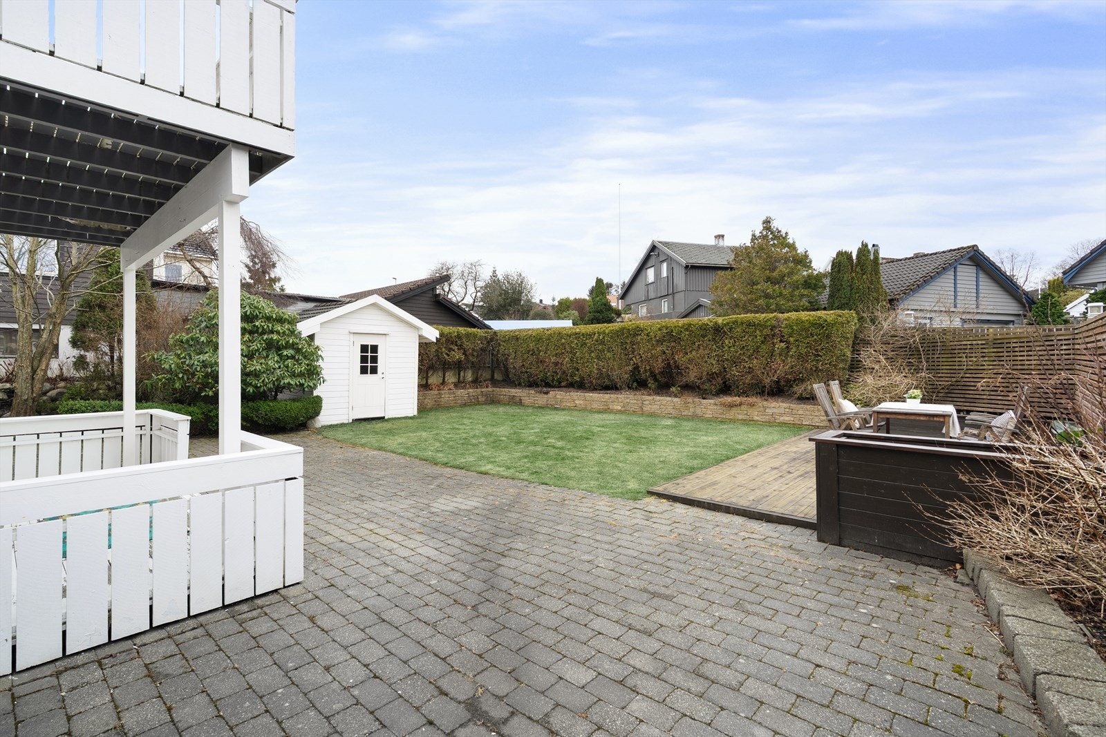 Uteområdet er pent opparbeidet med steinheller rundt deler av boligen, grill, plen, beplantning og terrasse. Galleribilde