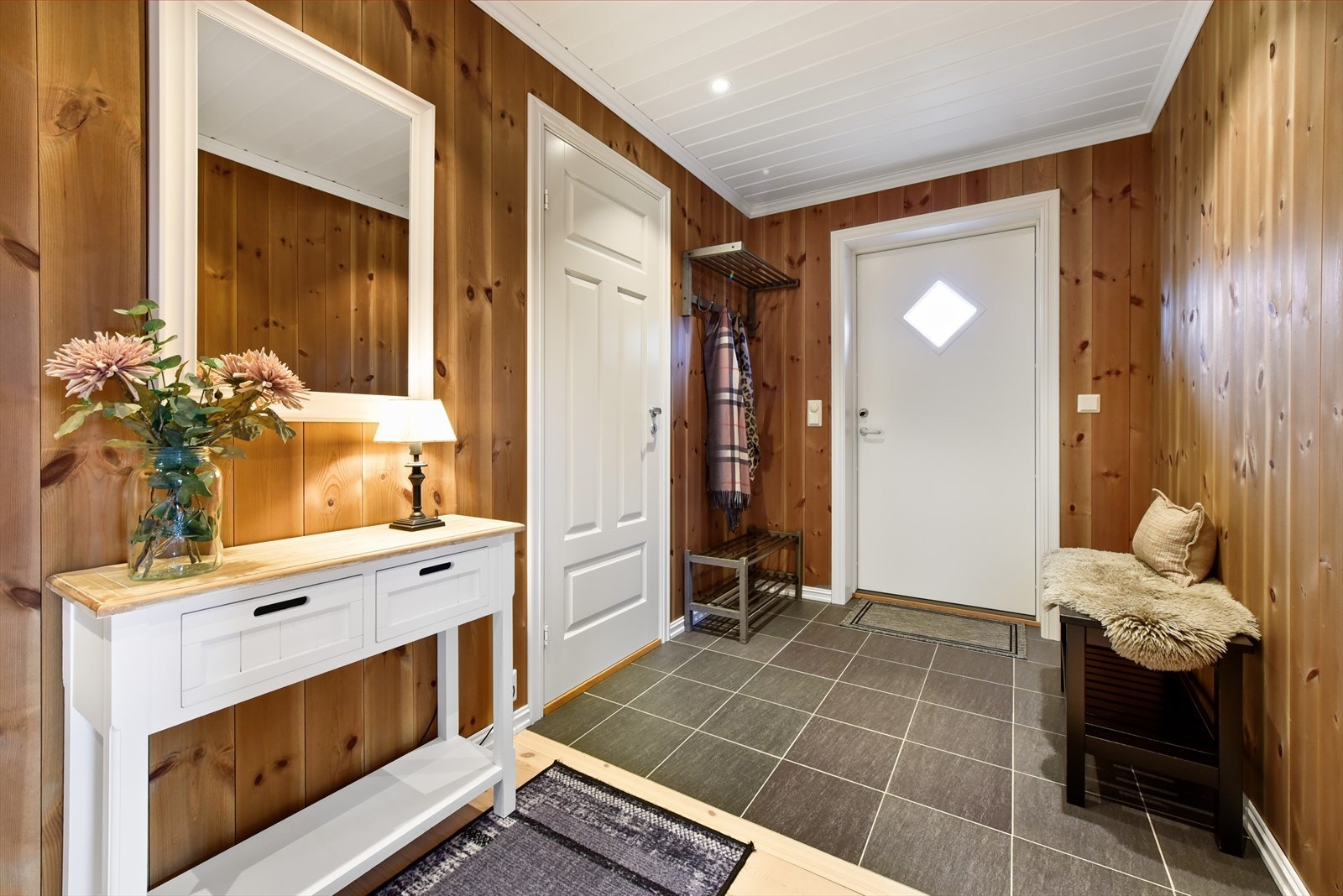 Entréen ønsker velkommen med varme i det flislagte gulvet og god plass til å henge fra seg yttertøy. Galleribilde