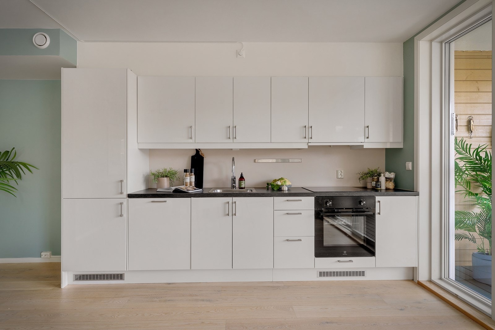 Det moderne kjøkkenet har slette fronter og rikelig med både skap- og benkeplass. Alle hvitevarer, inkludert kjøl/fryseskap, oppvaskmaskin, stekeovn og platetopp - er integrert, noe som gir et rent og sømløst inntrykk. Galleribilde