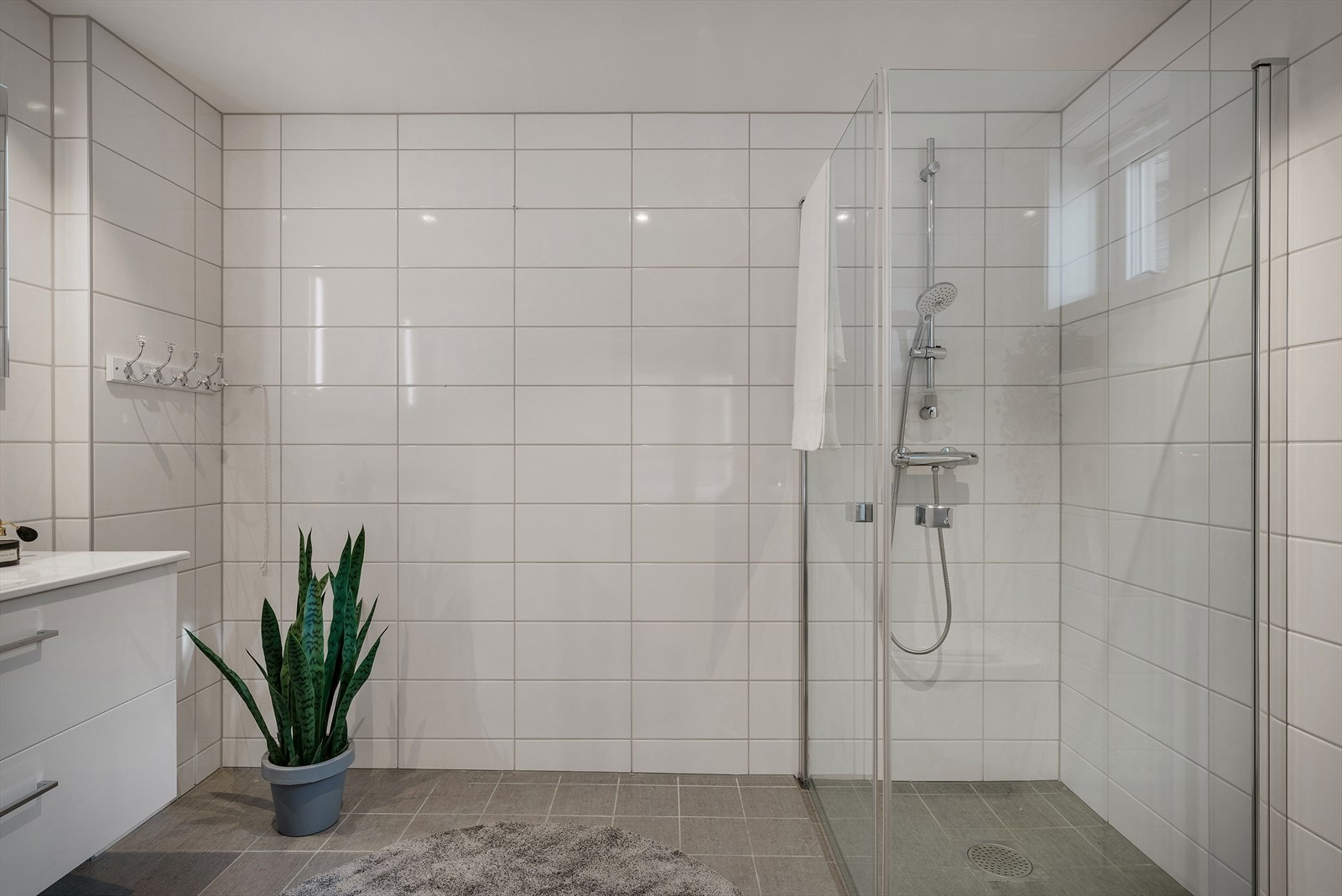 Badet har et stort dusjhjørne med innfellbare glassdører. Galleribilde