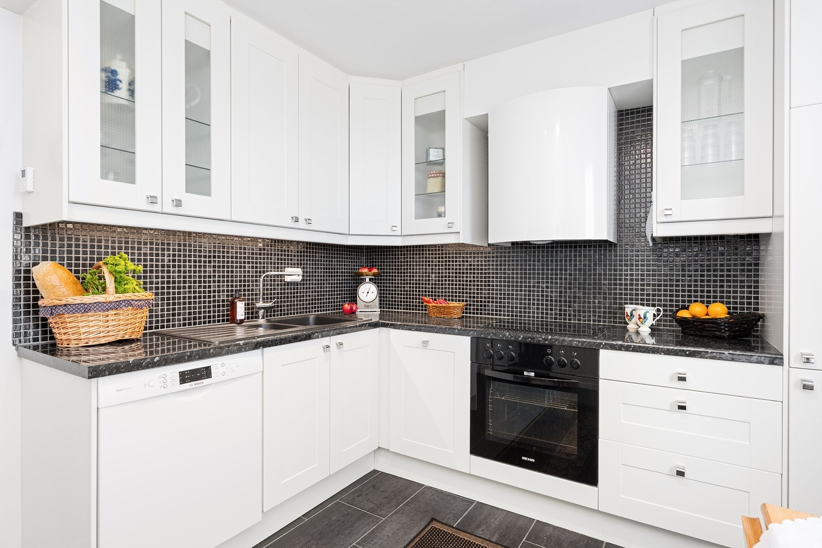 Kjøkkenet har god oppbevaringsplass i overskapene. Ellers god belysning under overskap og flislagt med mosaikkfliser i mellom over- og underskapene. Galleribilde