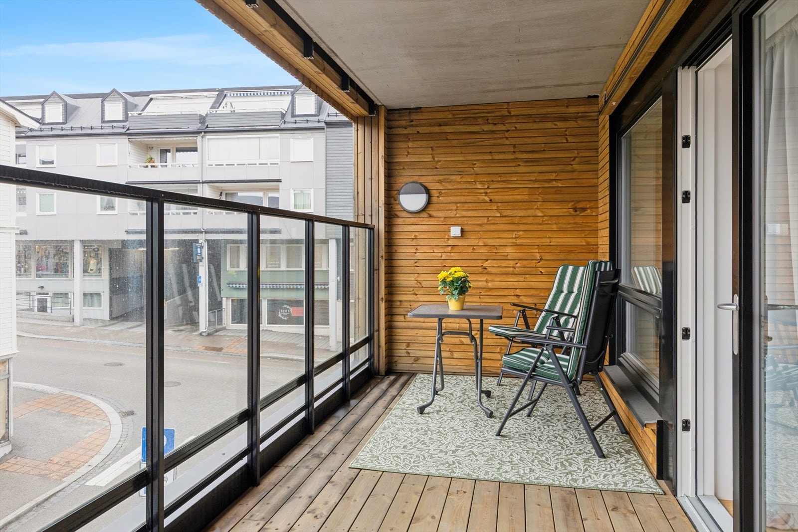 Balkongen er skjermet med trepanel og et 140 cm høyt rekkverk i glass og aluminium. Galleribilde