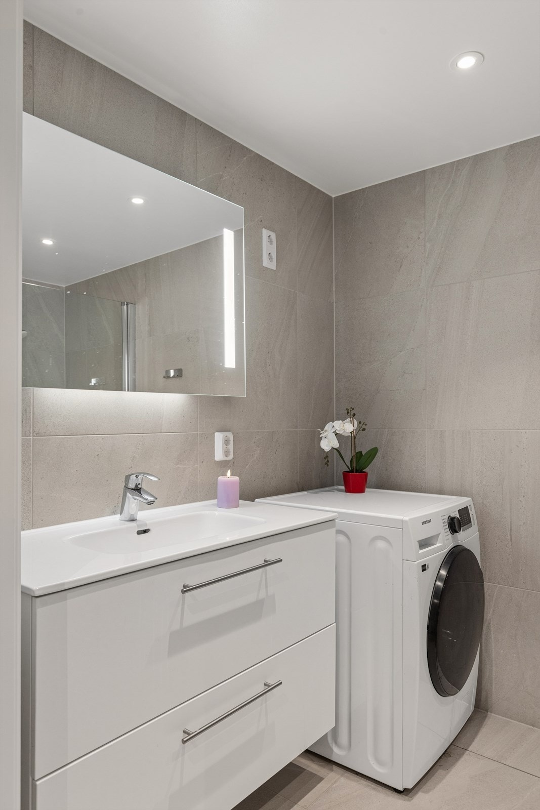 Badet er fra 2023, med flislagte overflater, servantskap og opplegg for vaskemaskin. Galleribilde