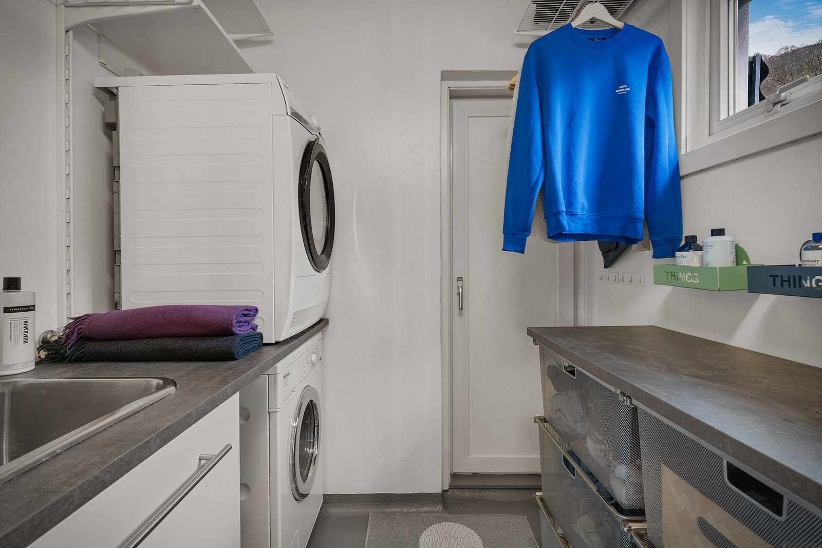 Vaskerommet er praktisk innredet med arbeidsbenk, skap og opplegg for vaskemaskin. Galleribilde