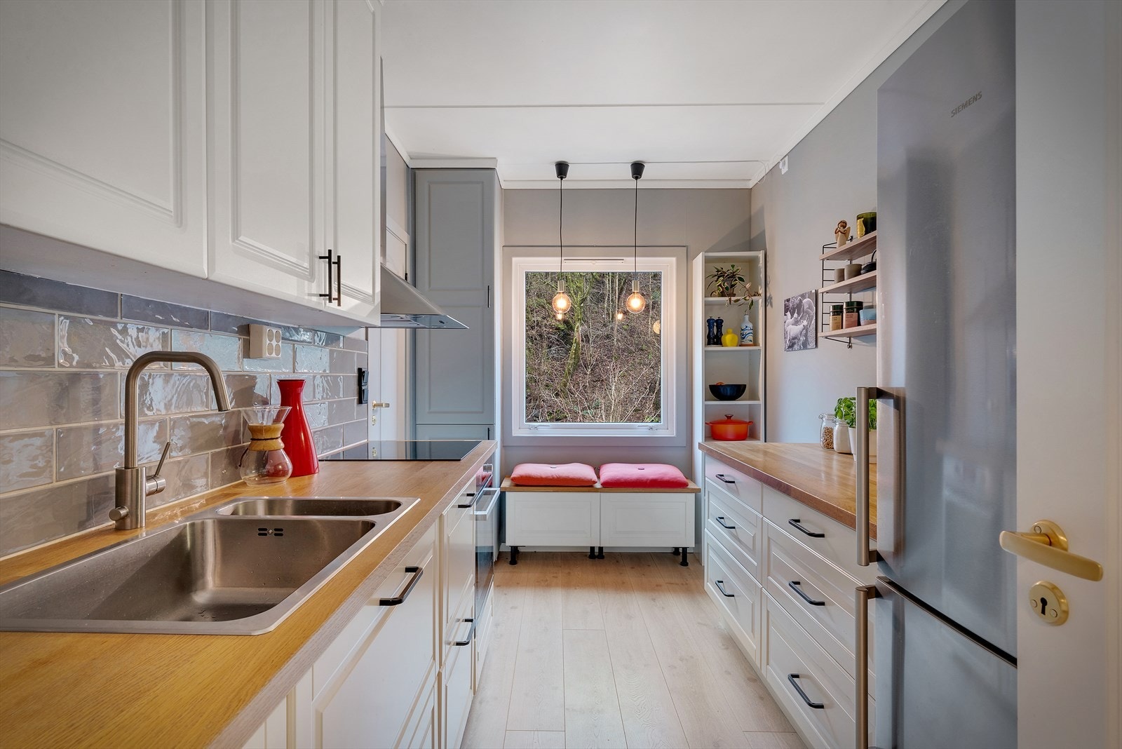 Kjøkkenet har en praktisk innredning med profilerte fronter, benkeplate i heltre og integrerte hvitevarer. Galleribilde