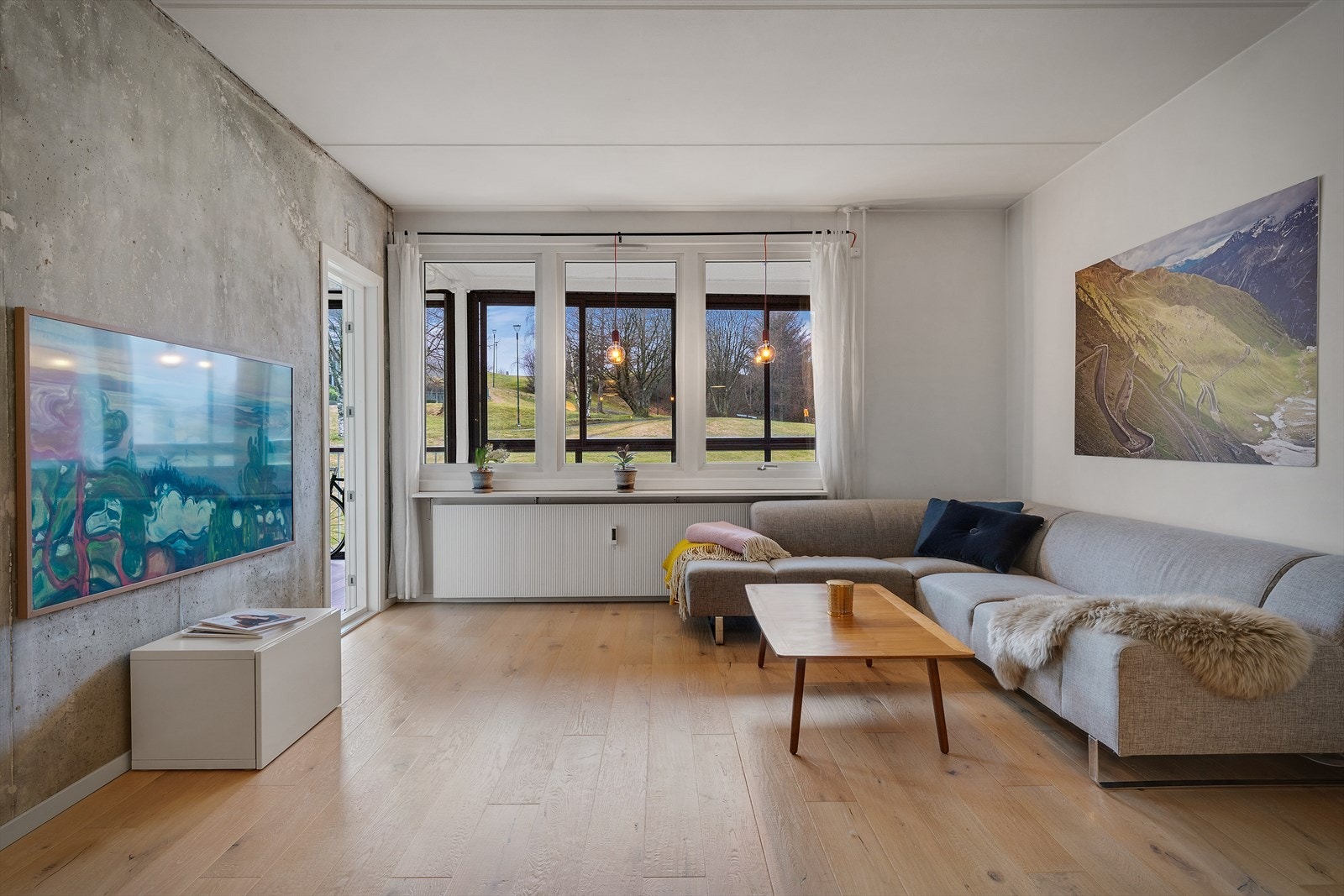 Stuen på ca. 23 m² har en karakterfull betongvegg og gulv med parkett og laminat med rustikk overflate. Galleribilde