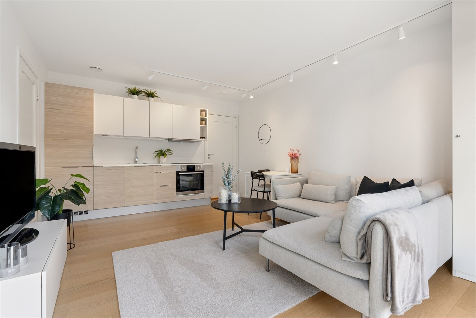 Kjøkken har fin, tidløs innredning med slette fronter og laminat benkeplate. Rommet har i tillegg plass til både sofakrok og spisebord. Galleribilde