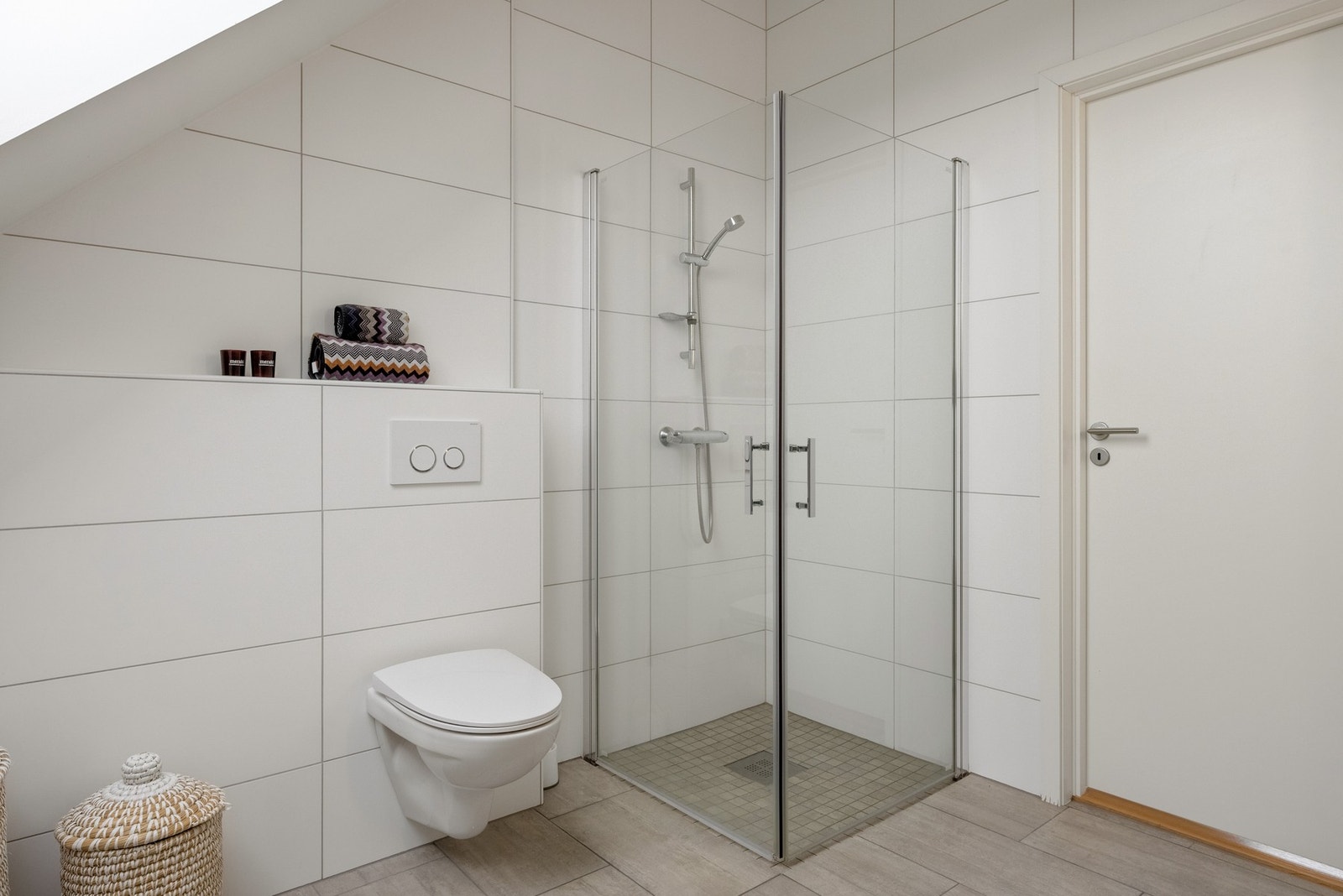 Det er flislagt på gulv og delvis på vegg, kombinert med malt platekledning. Det er også innfelte spotlights i himlingen. Varmekabler i gulv. Galleribilde