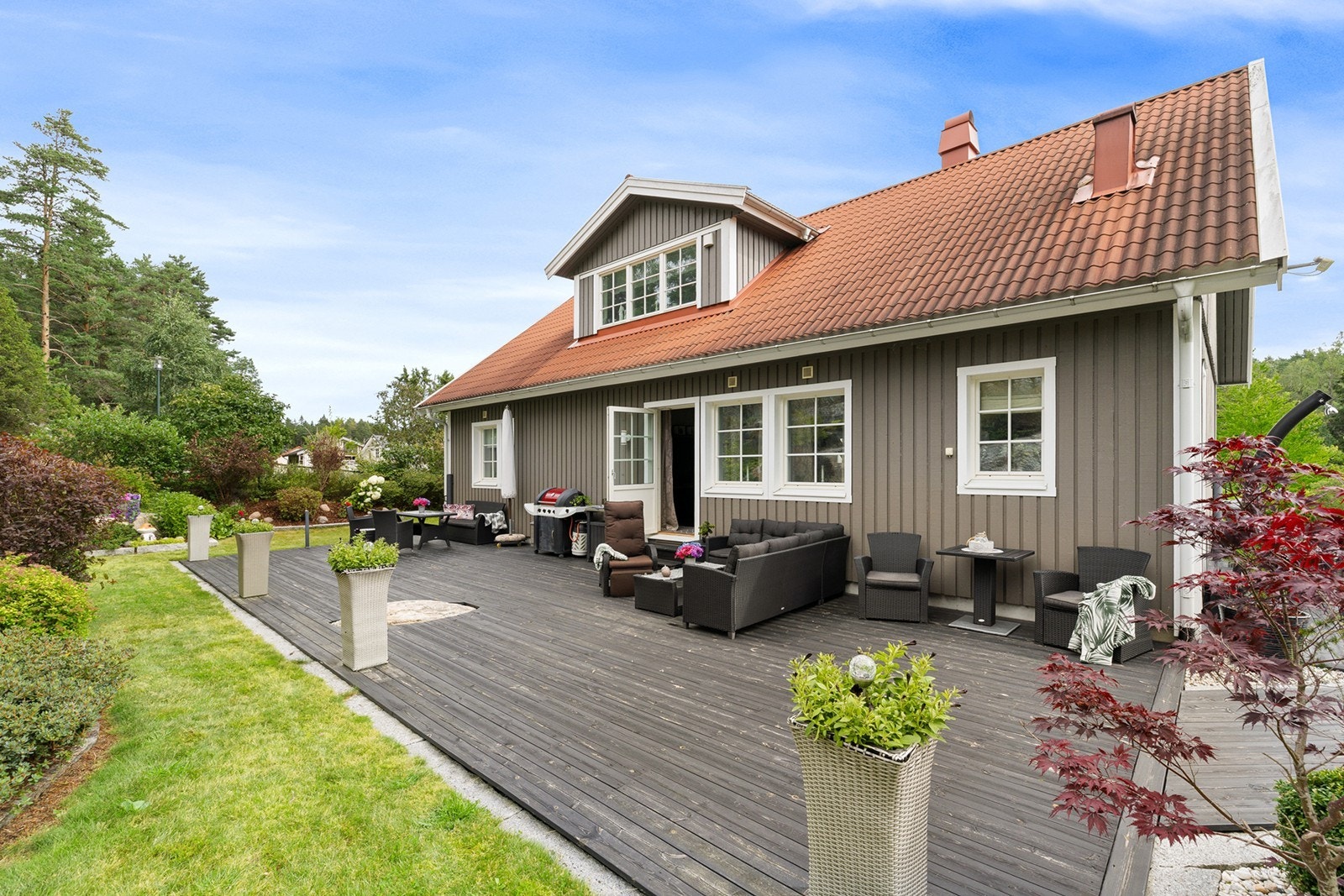 Den romslige terrassen rundt huset gir gode muligheter for både solrike dager og hyggelige sammenkomster utendørs. Galleribilde