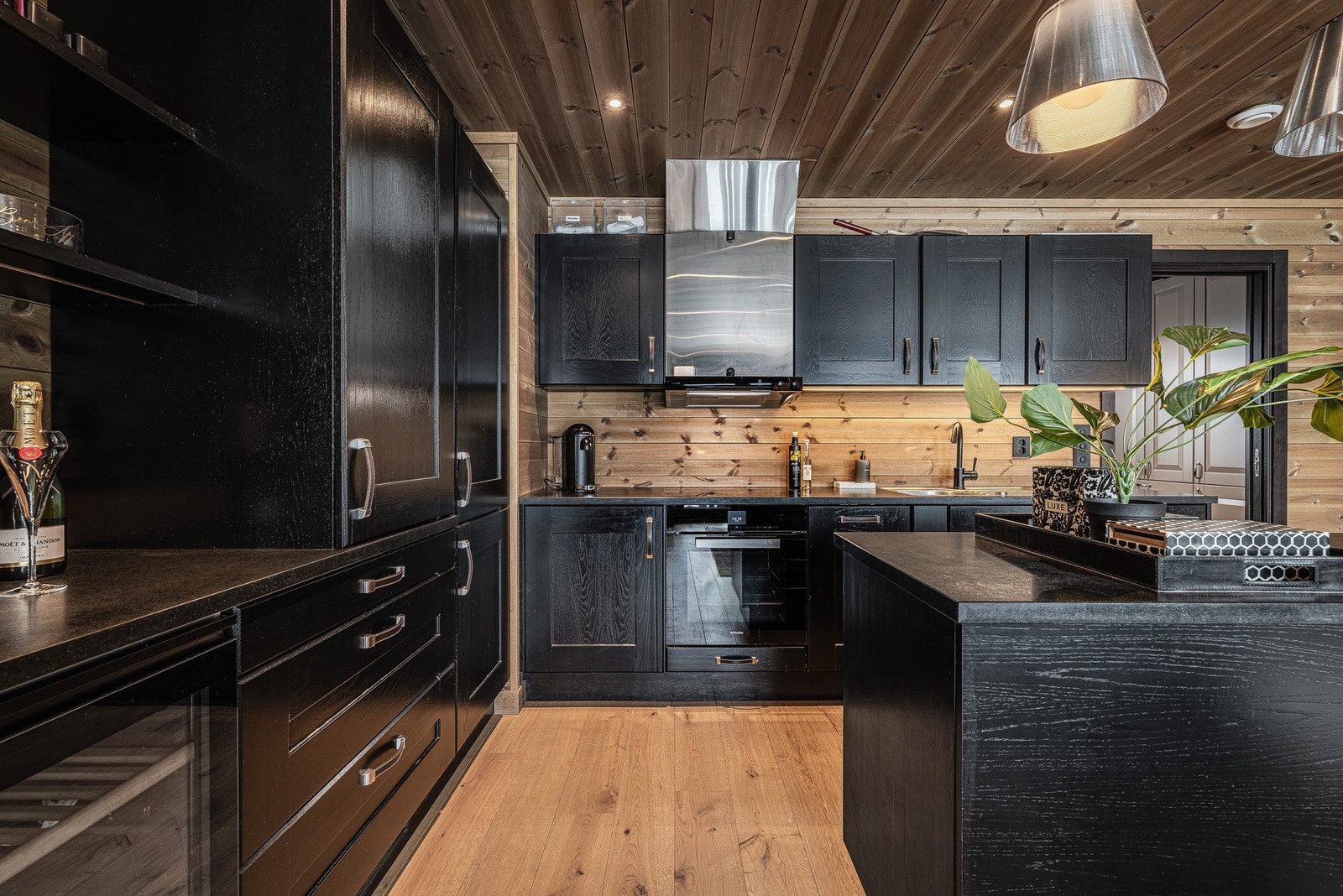 Åpen kjøkkenløsning med integrerte hvitevarer og en funksjonell kjøkkenøy som skaper en naturlig samlingsplass. Galleribilde