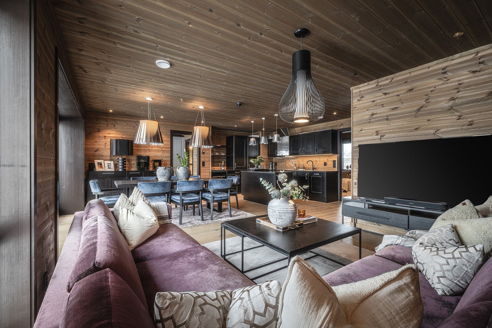 Stue, spisestue og kjøkken i en sømløs og sosial løsning - rommet oppleves åpent og luftig, med naturlige soner som flyter elegant over i hverandre. Galleribilde