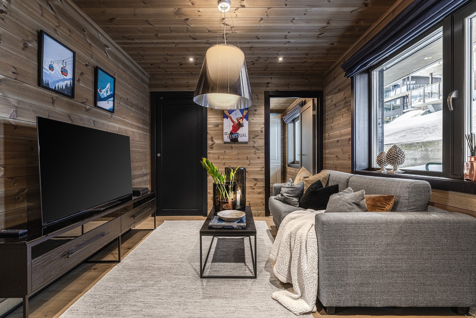 Innbydende TV-stue med åpen løsning og store vindusflater som slipper inn rikelig med lys. Galleribilde