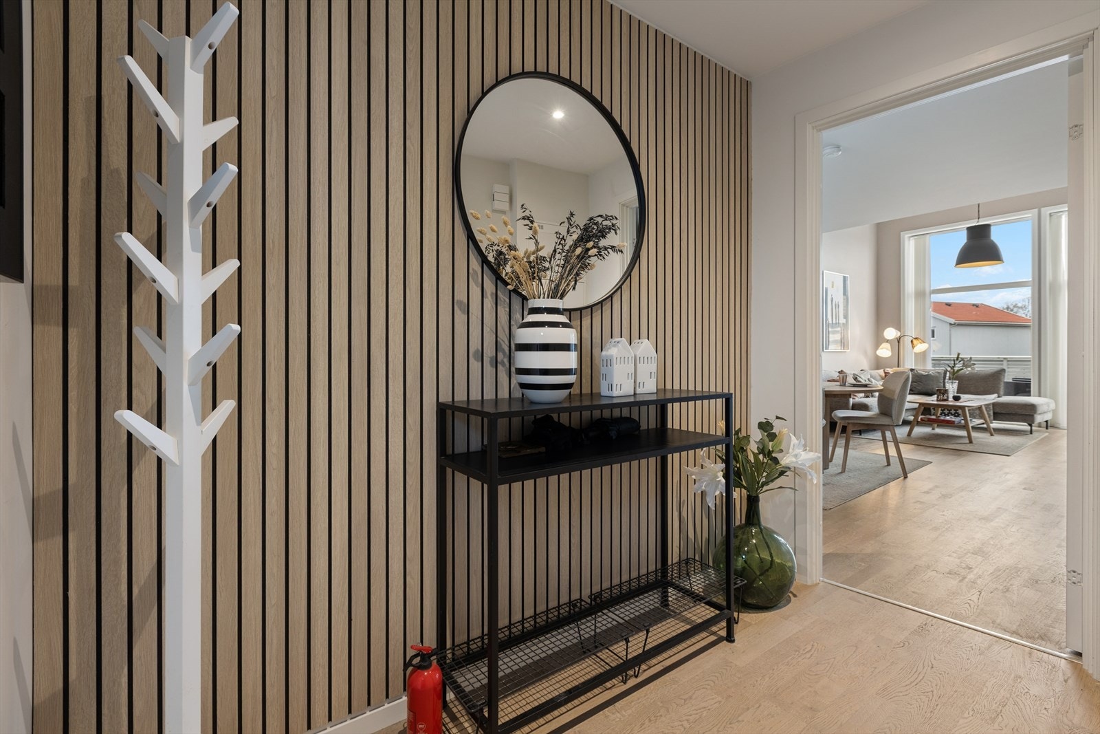 Man ønskes velkommen inn i en romslig entré hvor man har god plass til å henge fra seg yttertøy og sko. Entreen er innredet med en flott spilevegg som gir et moderne uttrykk og et godt førsteinntrykk av boligen. Galleribilde