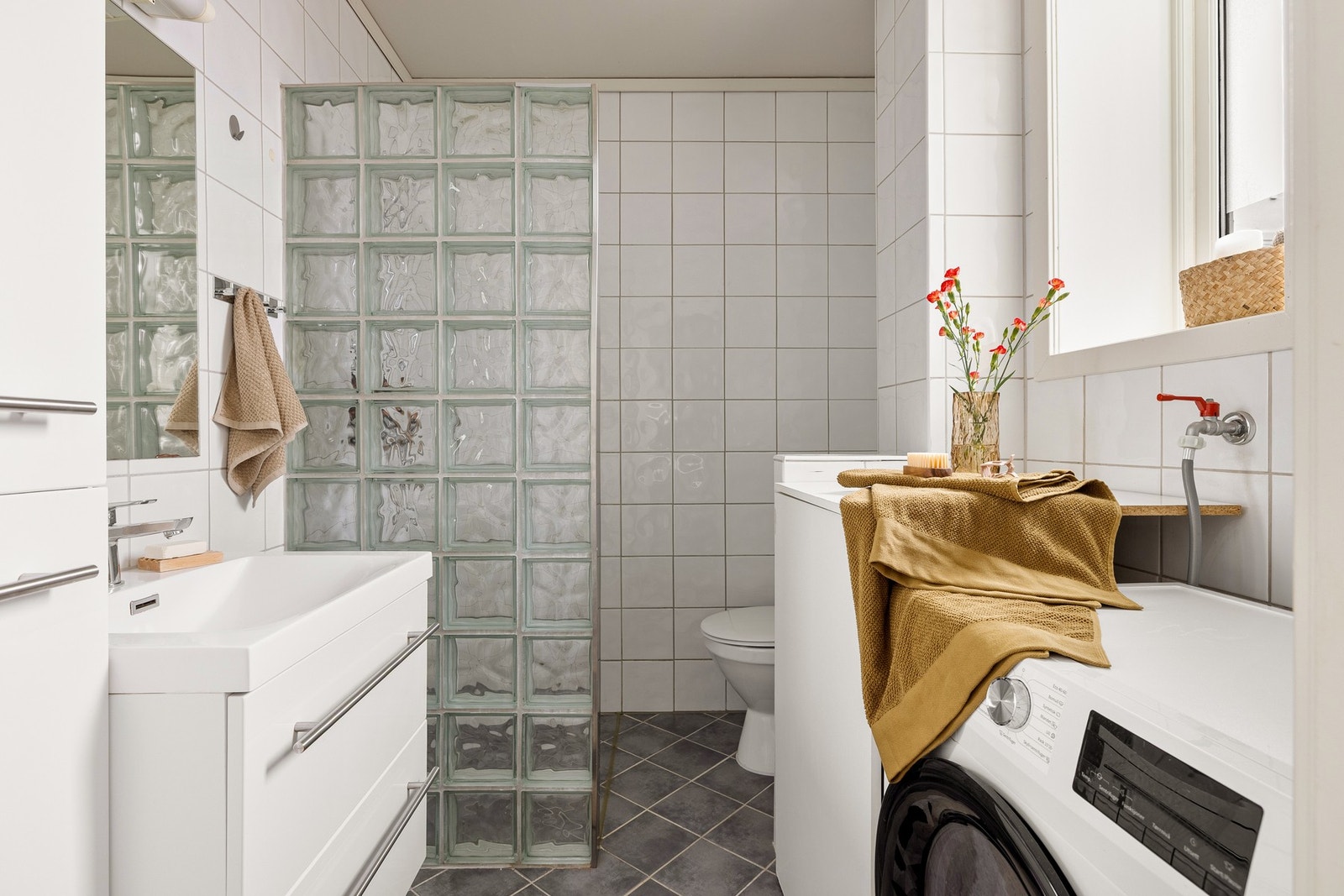Badet måler 4,1 kvm og er helfliset med varmekabler. Praktisk innredet med dusjnisje, baderomsinnredning, toalett, varmtvannstank og opplegg for vaskemaskin. Galleribilde