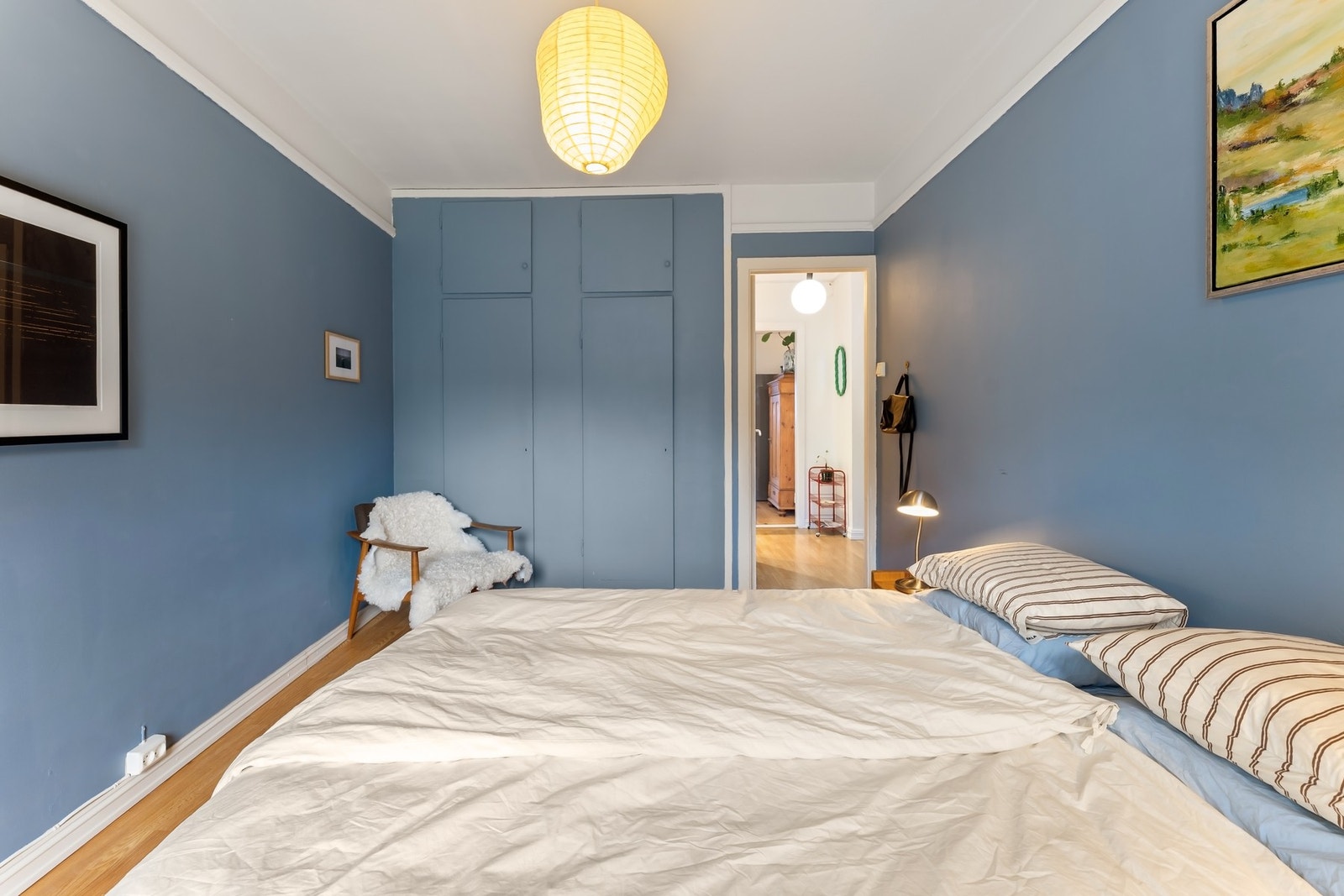 Det er plassbygde garderobeskap med malte fronter som gir god plass til oppbevaring og lagring Galleribilde