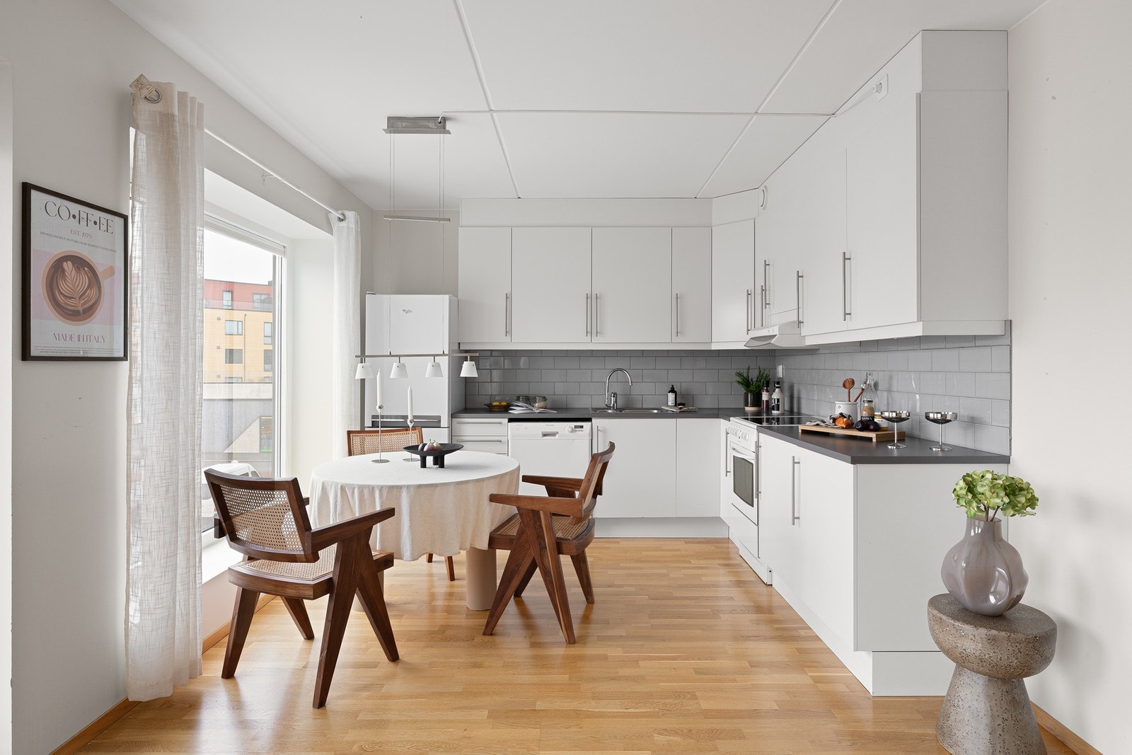 Kjøkkeninnredning med hvite slette fronter og benkeplate i laminat. Galleribilde