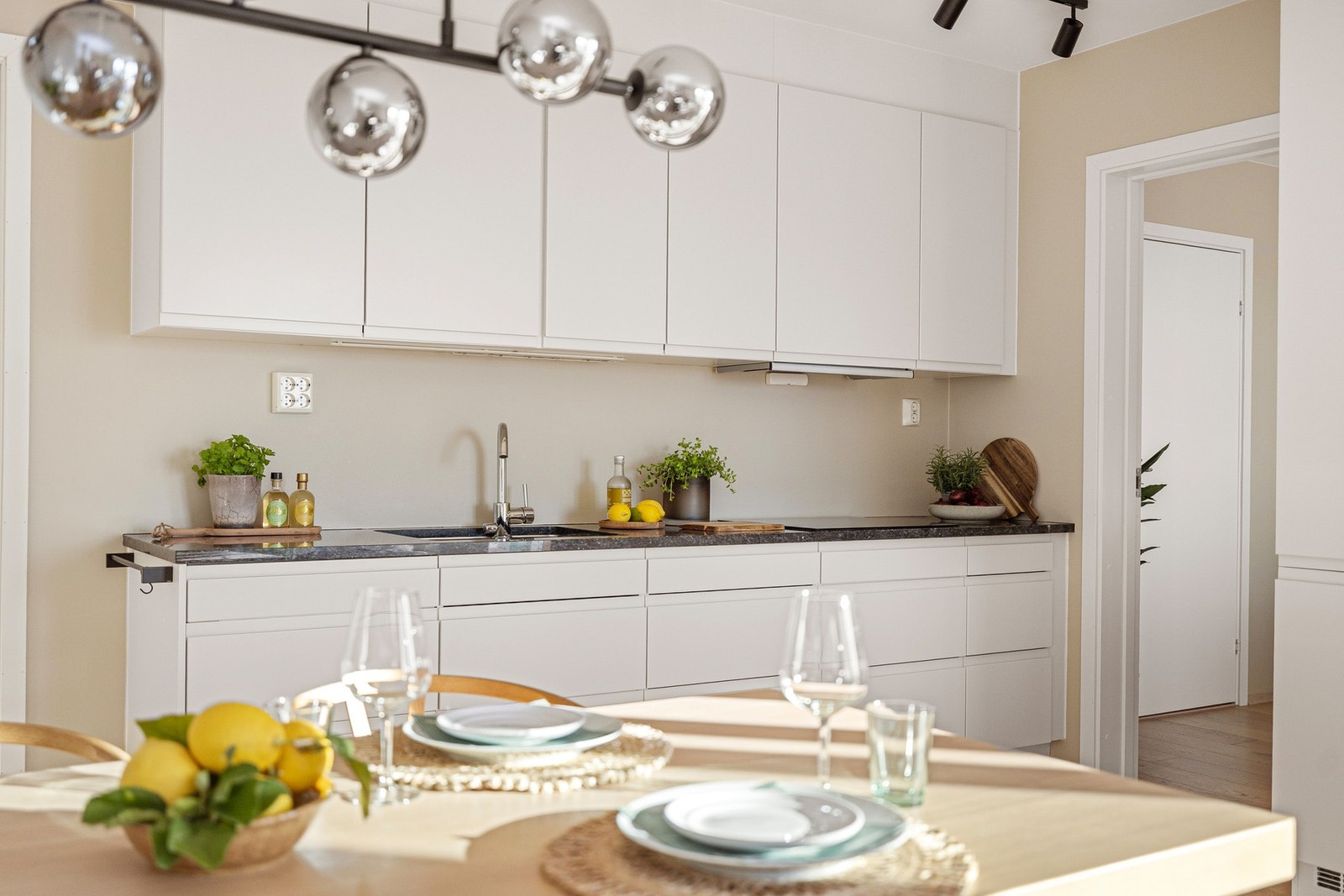 Innredningen har glatte fronter og solid benkeplate i stein med slitesterk overflate. Praktisk og fint med benkebelysning og stikkontakter over kjøkkenbenken. Galleribilde