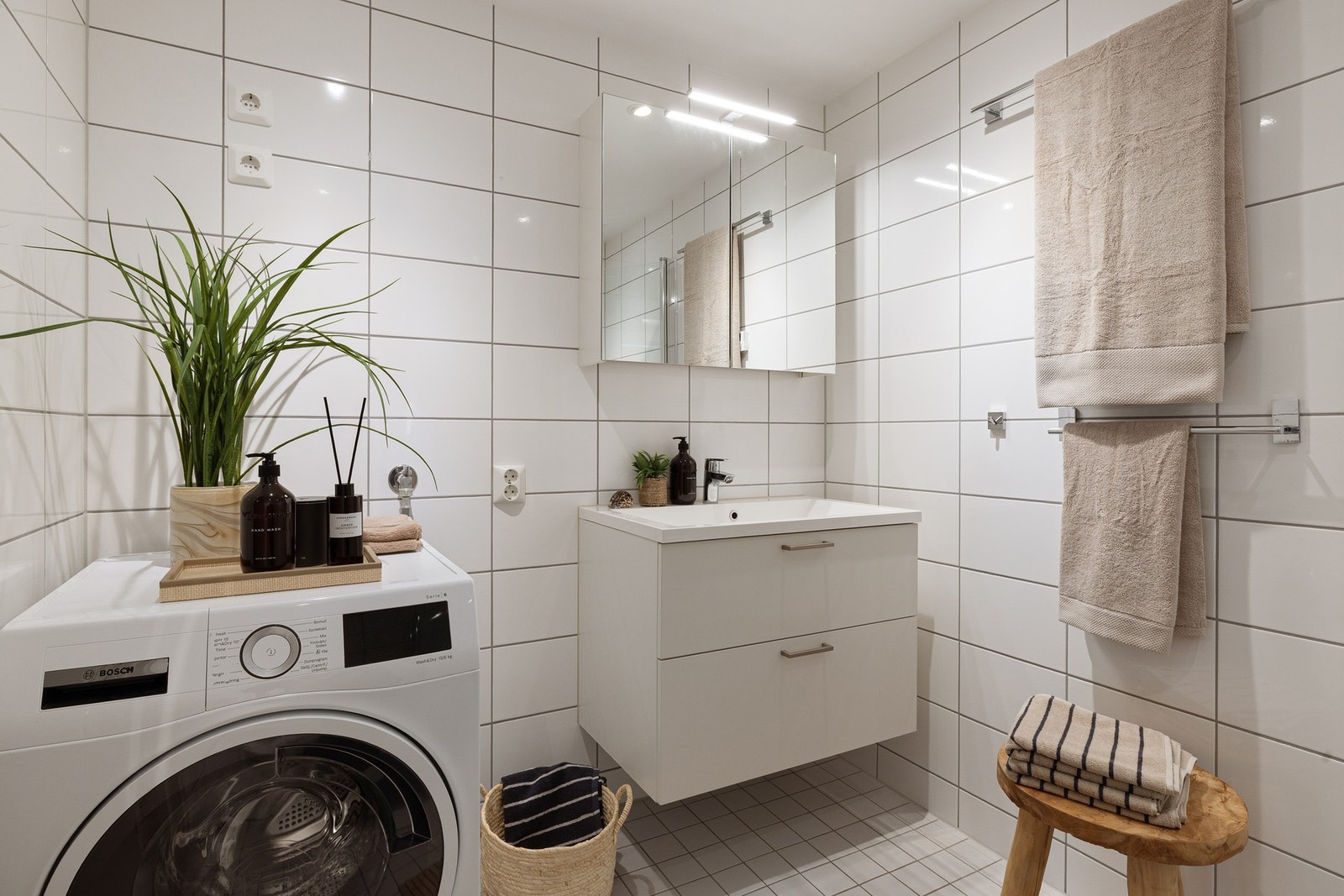 Moderne baderomsinnredning med skuffer og heldekkende servant, vegghengt speilskap over. Galleribilde