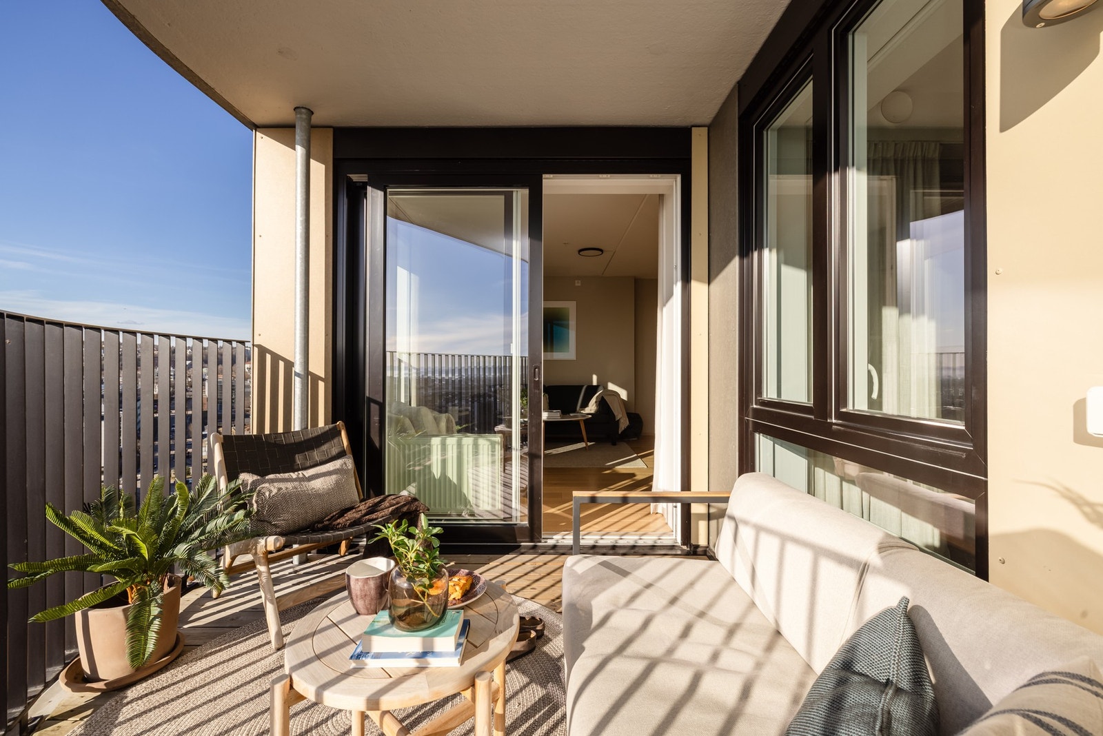 Balkongen er overbygget, har terrassebord på gulv og rekkverk av metall. Galleribilde