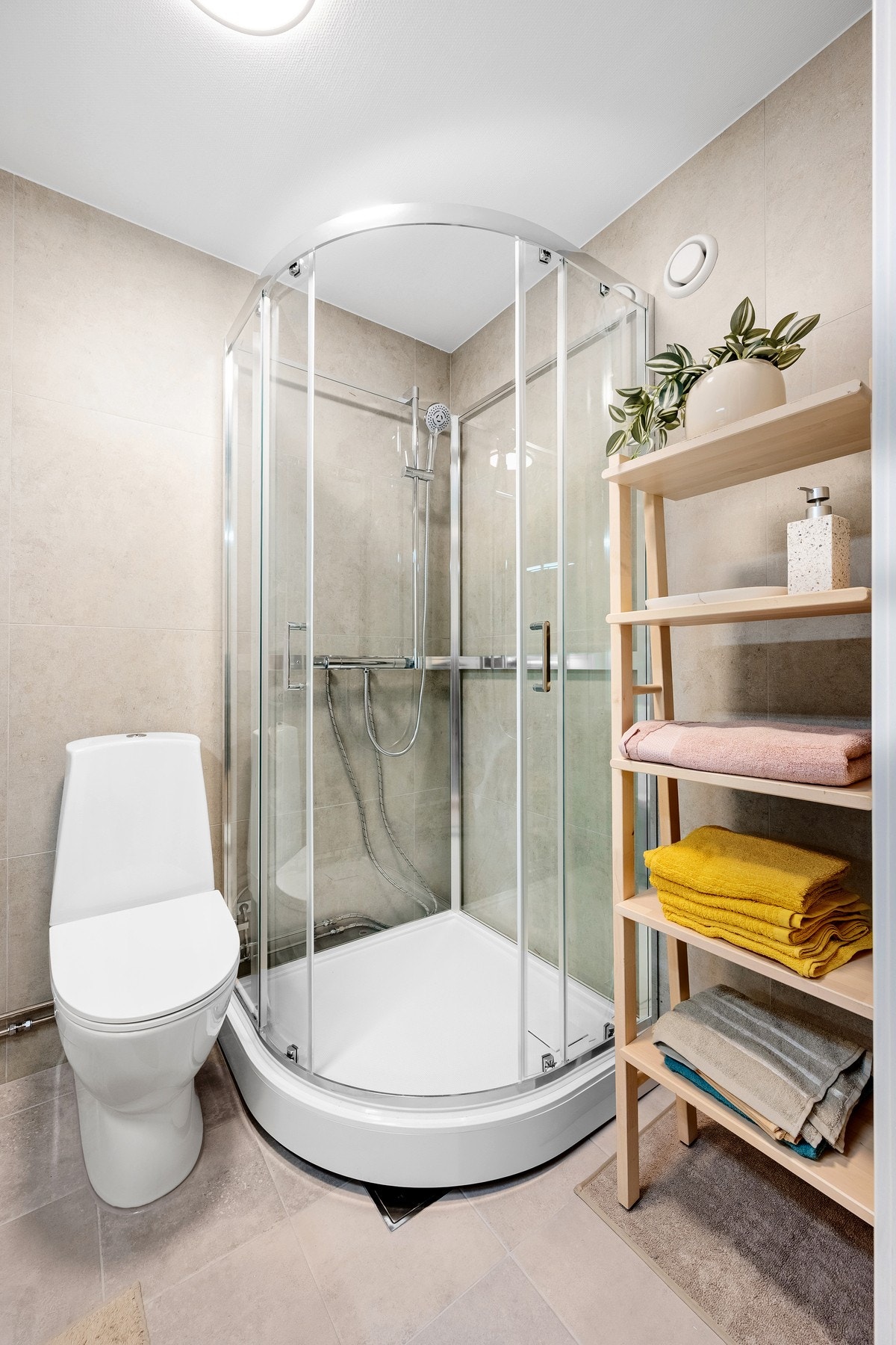 Badet fremstår moderne med nye fliser og ny innredning. Vegger og gulv er helfliset, mens taket er malt i en lys og ren utførelse. Galleribilde