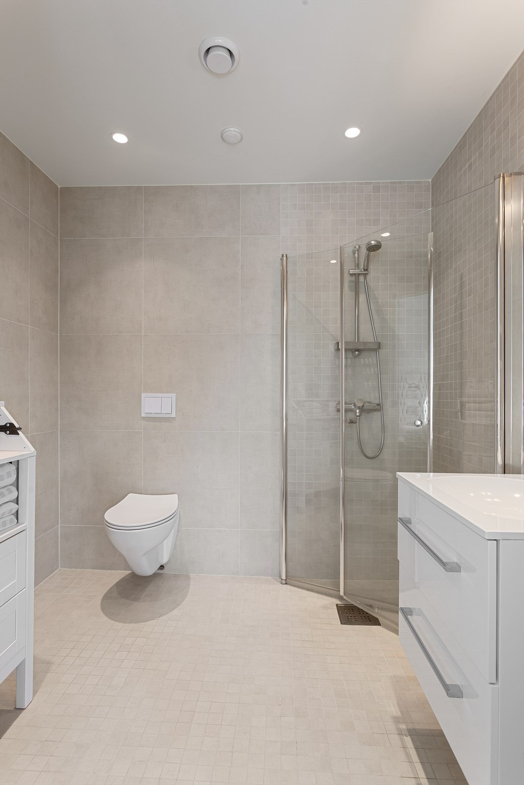 Badet har dusjhjørne med foldedører av glass Galleribilde