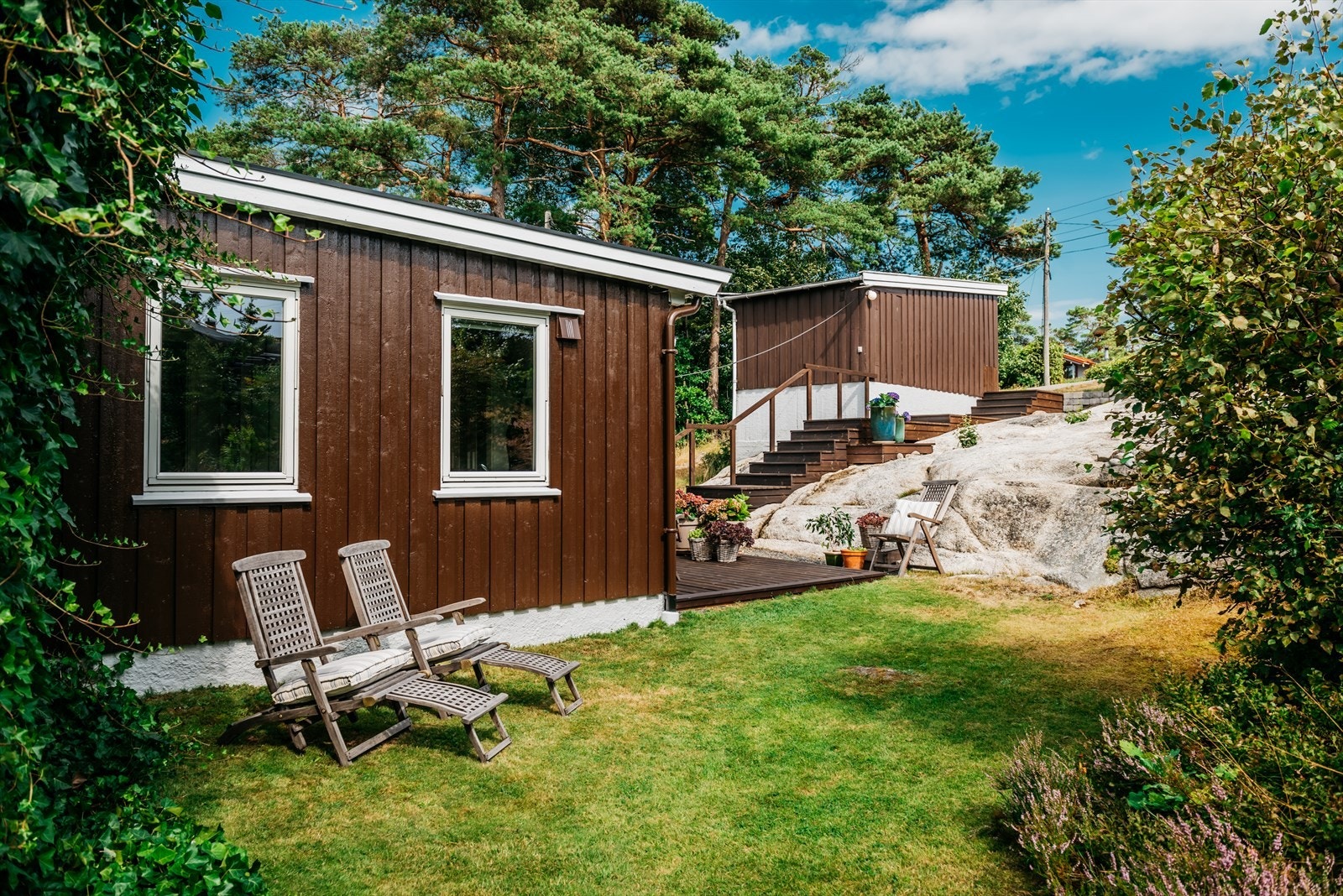 Tomten er pent opparbeidet med plen, frodig beplantning og fjell. Galleribilde