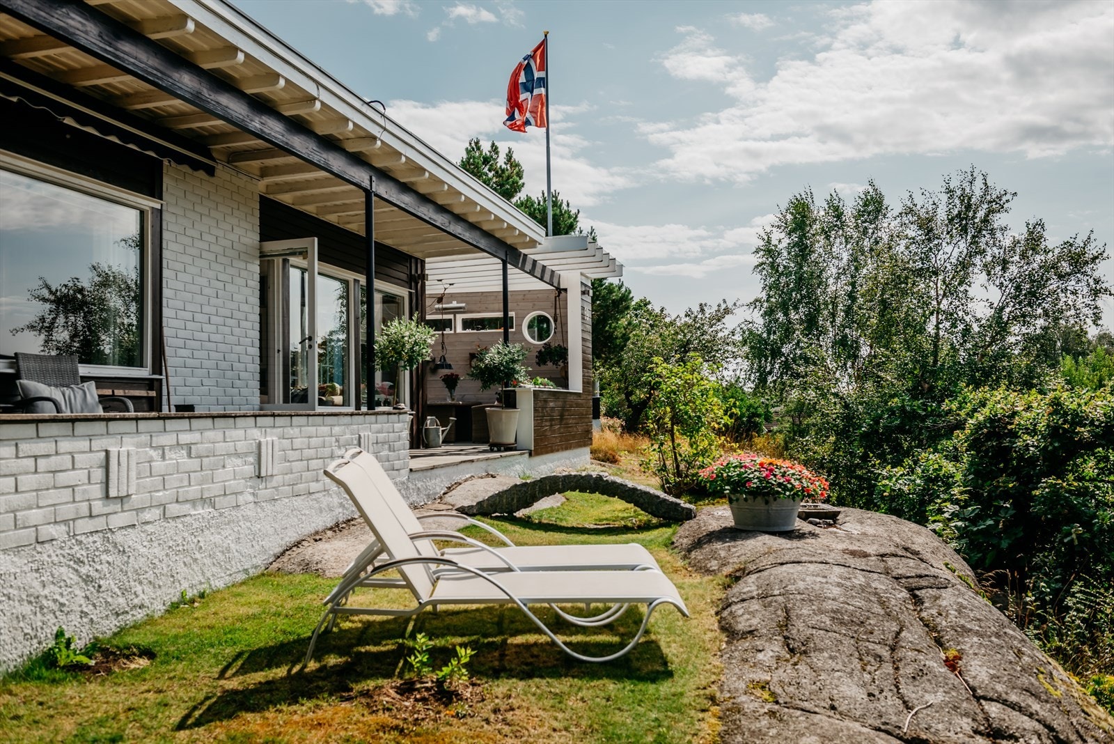 Flere sitteplasser rundt boligen gjør det enkelt å flytte seg etter solen - eller finne en sval plass i skyggen. Galleribilde