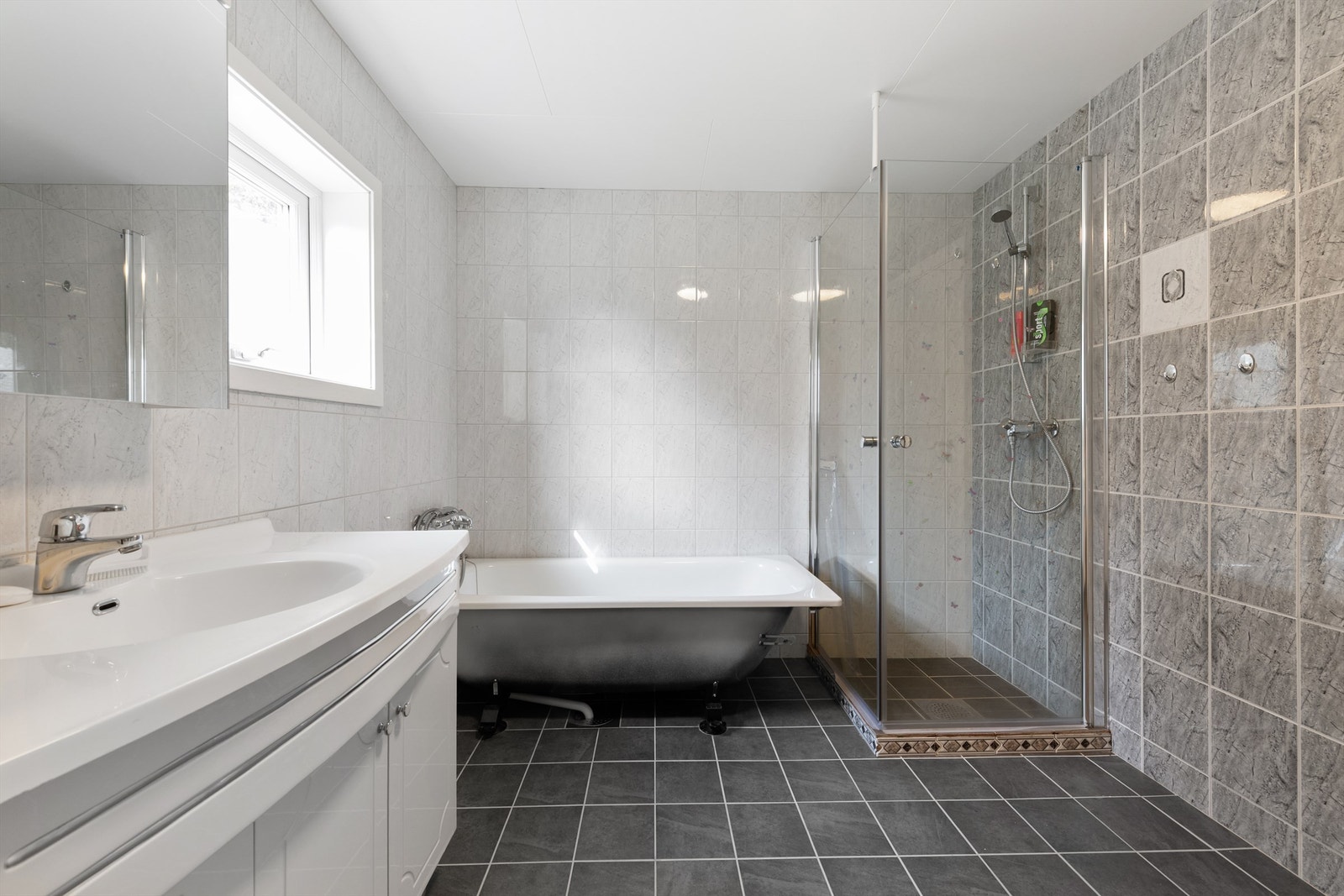 Badet ble oppgradert i 2014 og har flislagt gulv med gulvvarme, samt både dusjhjørne og frittstående badekar Galleribilde