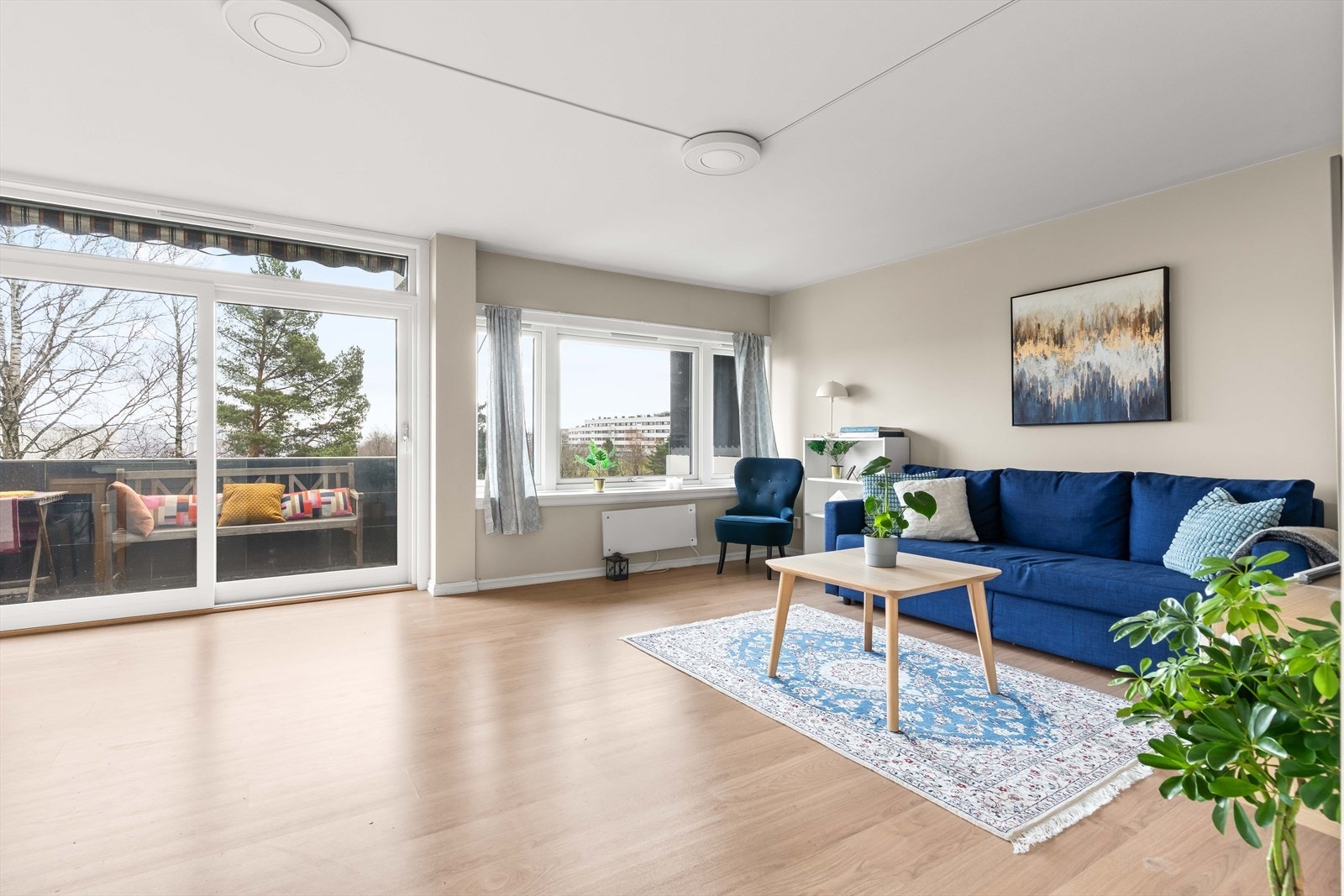 Leiligheten har en stor og luftig stue, med skyvedør ut til en hyggelig balkong. Galleribilde