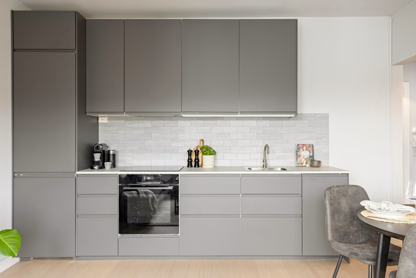 Kjøkkeninnredningen har moderne, glatte fronter, laminert benkeplate og vinylfliser over benk. Galleribilde