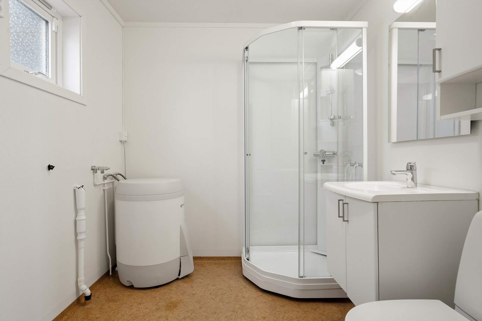 Badet har innredning med nedfelt servant, toalett, dusjkabinett (mangler garnityr) og opplegg for vaskemaskin Galleribilde