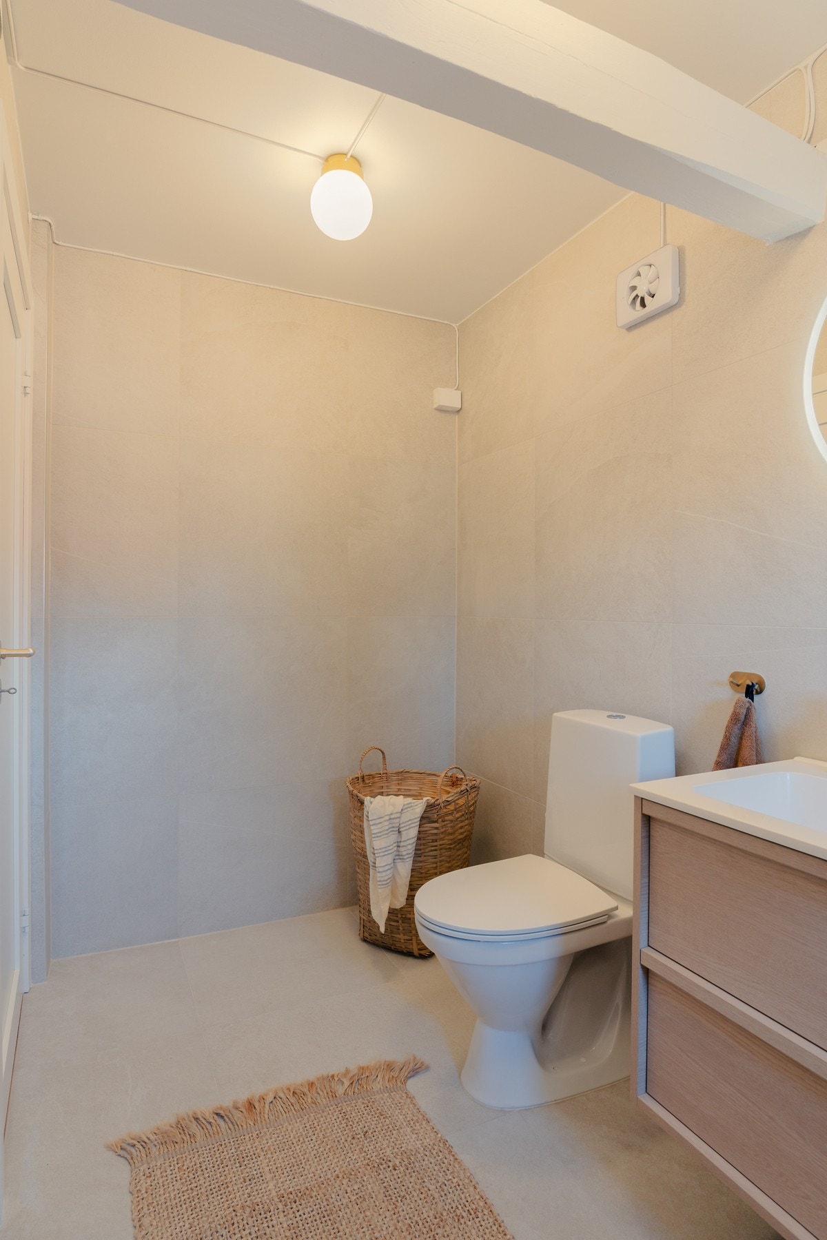 Det er elegant innredet med veggmontert servantskap, gulvstående toalett og opplegg for vaskemaskin. Galleribilde