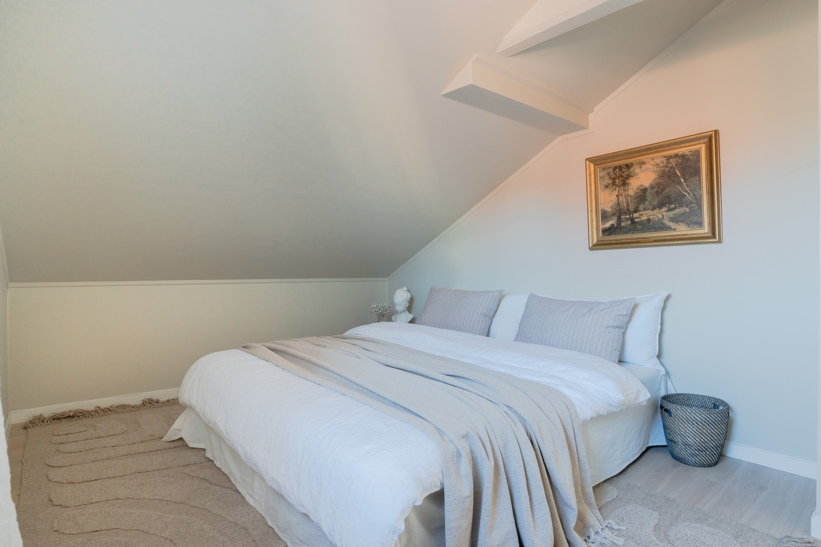 Skråtak og synlige, malte takbjelker gir karakter og sjarme, samtidig som rommene oppleves åpne og innbydende. Galleribilde