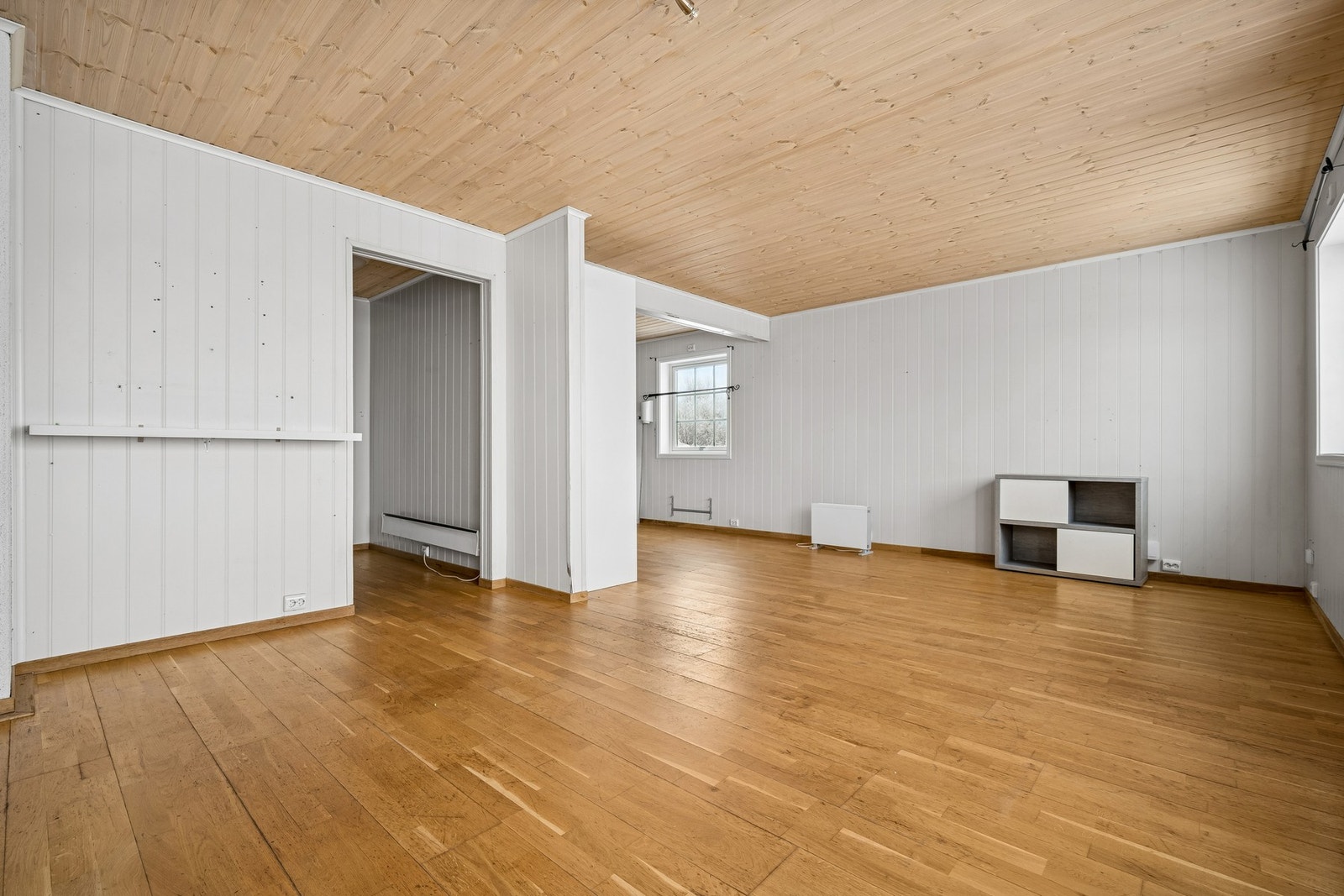 L-formet stue- og kjøkkenløsning som skaper både luft og naturlig soneinndeling Galleribilde