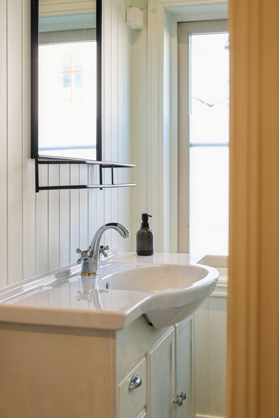 Badet har panel på veggene og flislagt gulv med varmekabler. Galleribilde