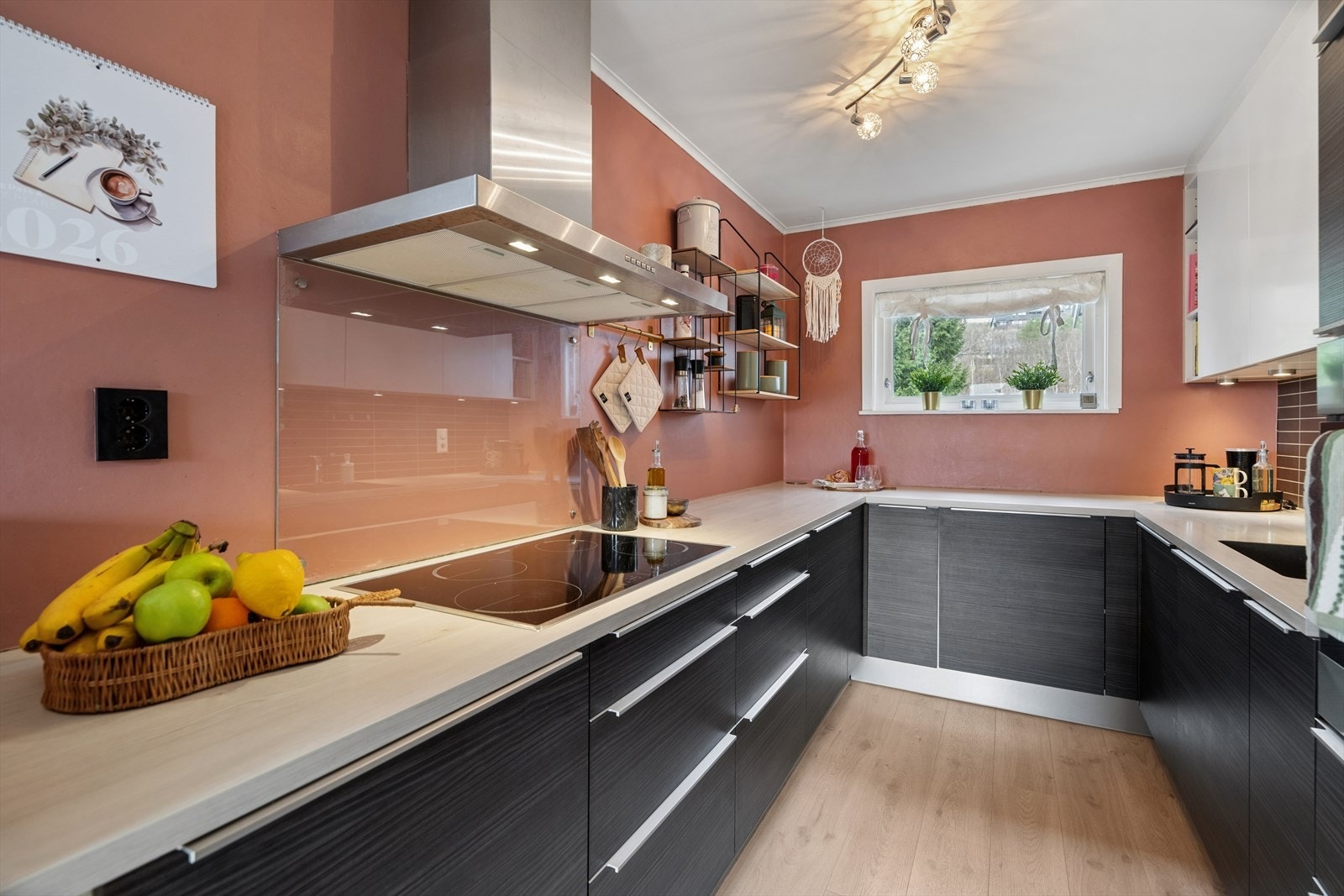 Over deler av benkeplaten er det montert en backsplash med flismønster, og bak platetoppen er det satt opp en praktisk glassplate. Galleribilde