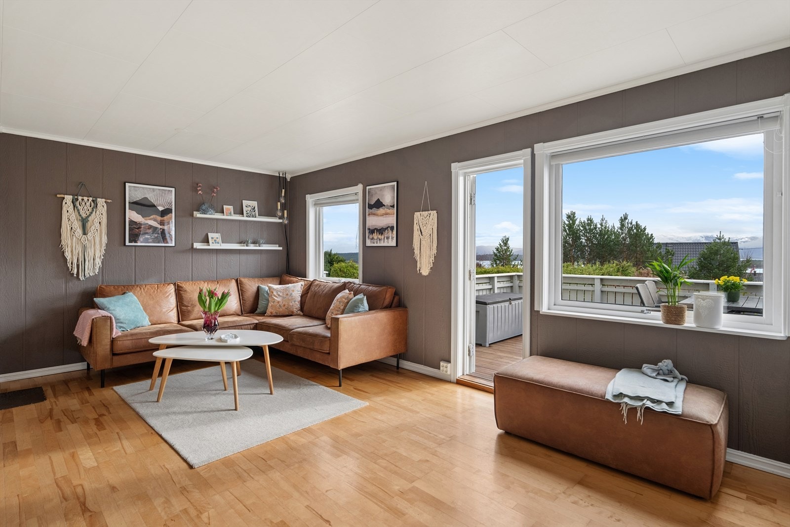 Stuen har store vindusflater som slipper inn rikelig med naturlig lys og gir rommet en lys og luftig atmosfære. Galleribilde