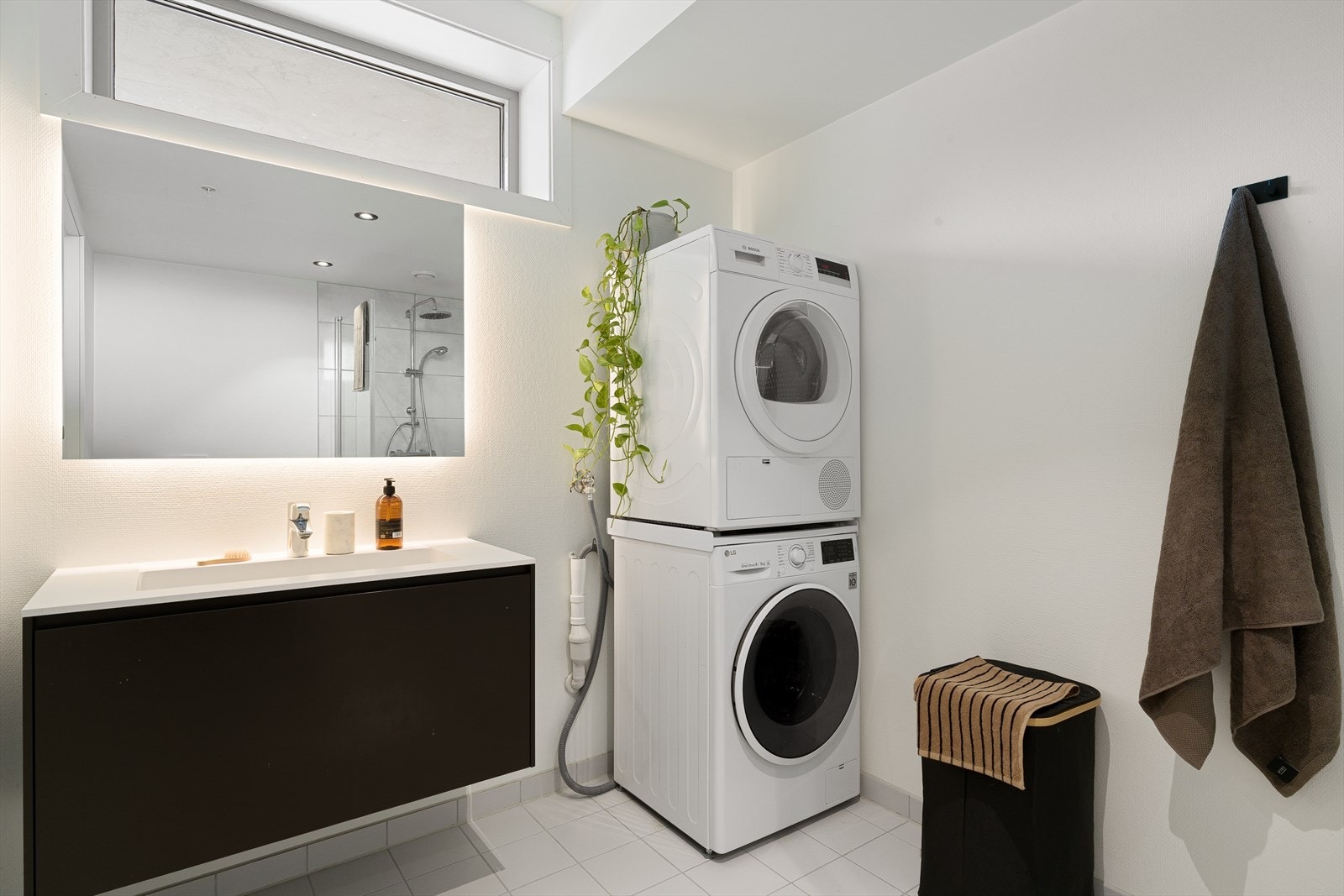 Badet er innredet med vegghengt servant med innebygd belysning på speilet, og elektriske varmekabler i gulv. Det er opplegg for vaskemaskin. Galleribilde