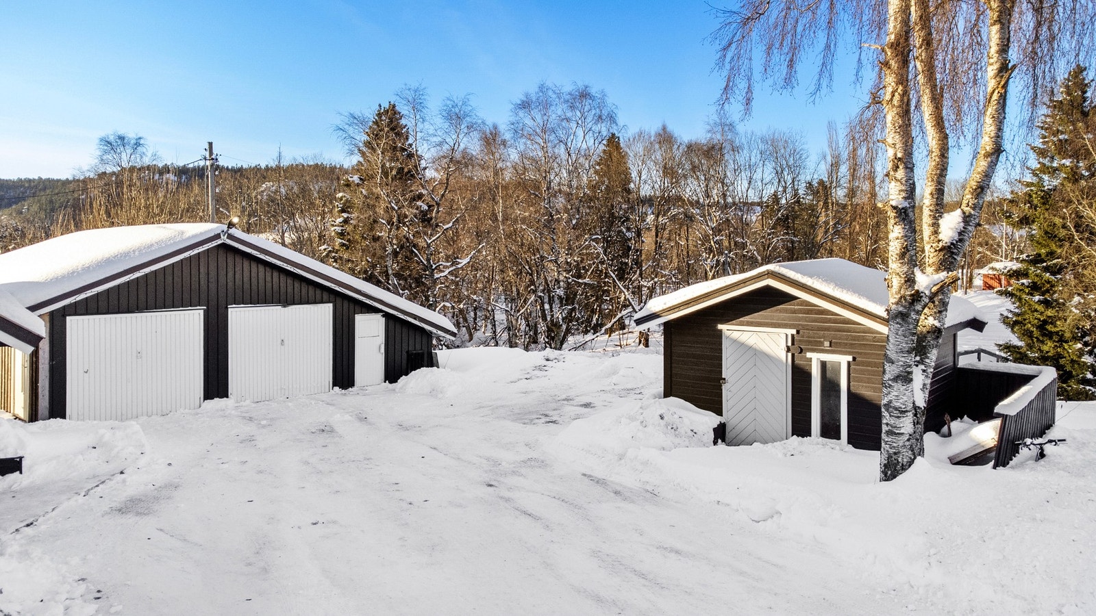Romslig gårdsplass med garasje og redskapsbod. Galleribilde