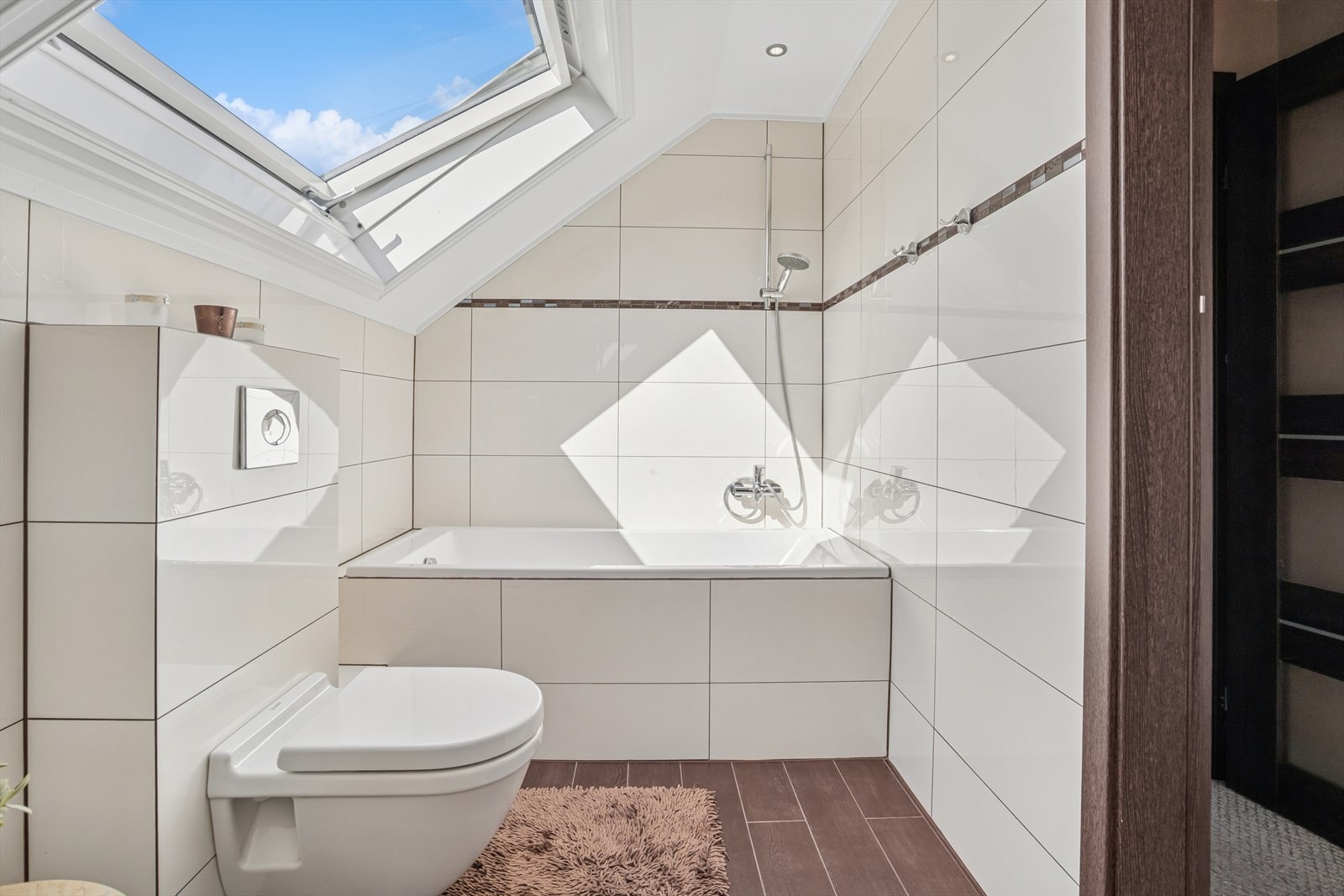 Baderommet i andre etasje er innredet med badekar, vegghengt toalett, servant, innredning med skuffer og speil. Galleribilde