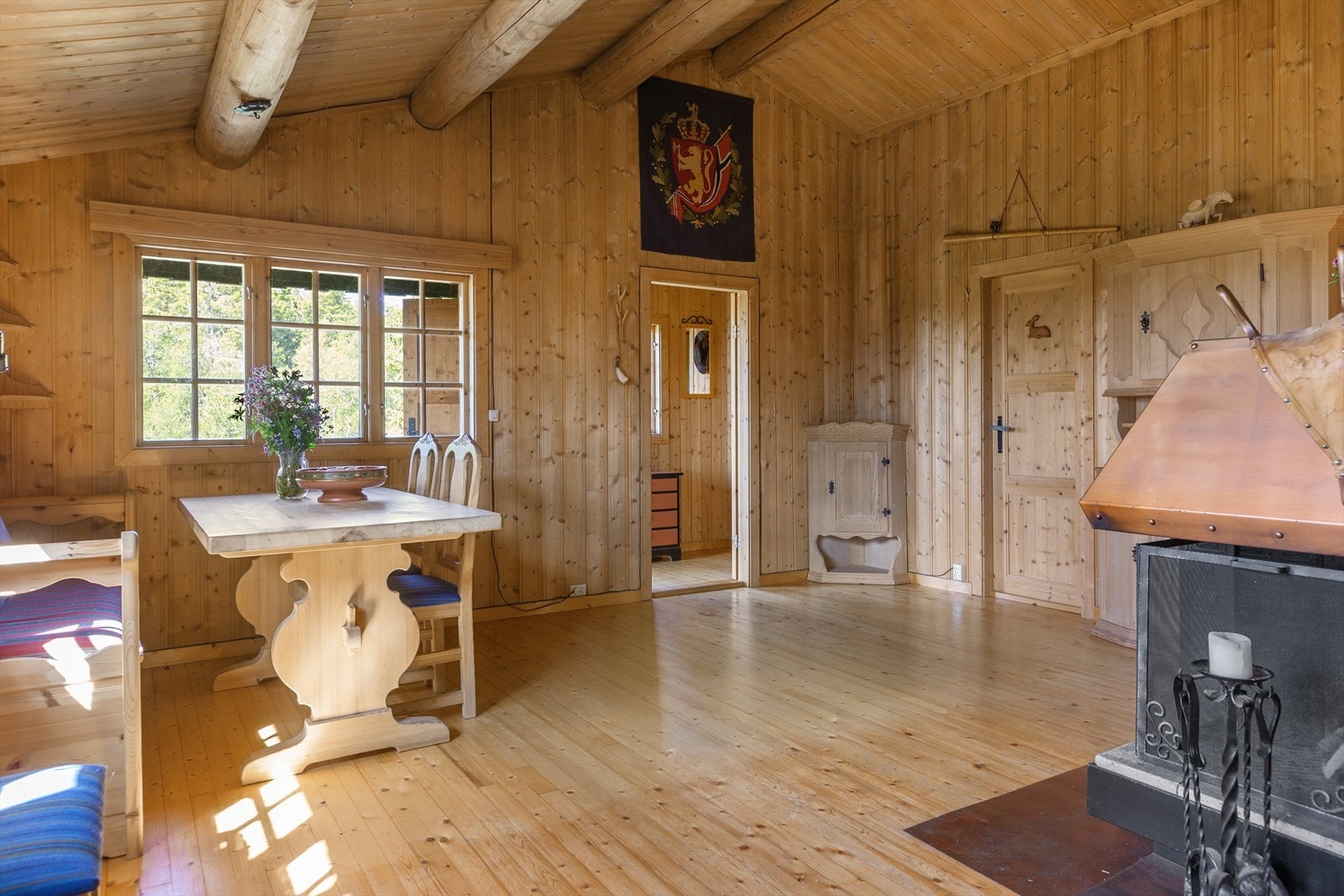 Fra entréen kommer du inn i en hyggelig spisestue med raustet himling, synlige tømmeråser og mange vinduer som slipper inn mye lys og som gir deg godt utsyn til naturen utenfor. Galleribilde
