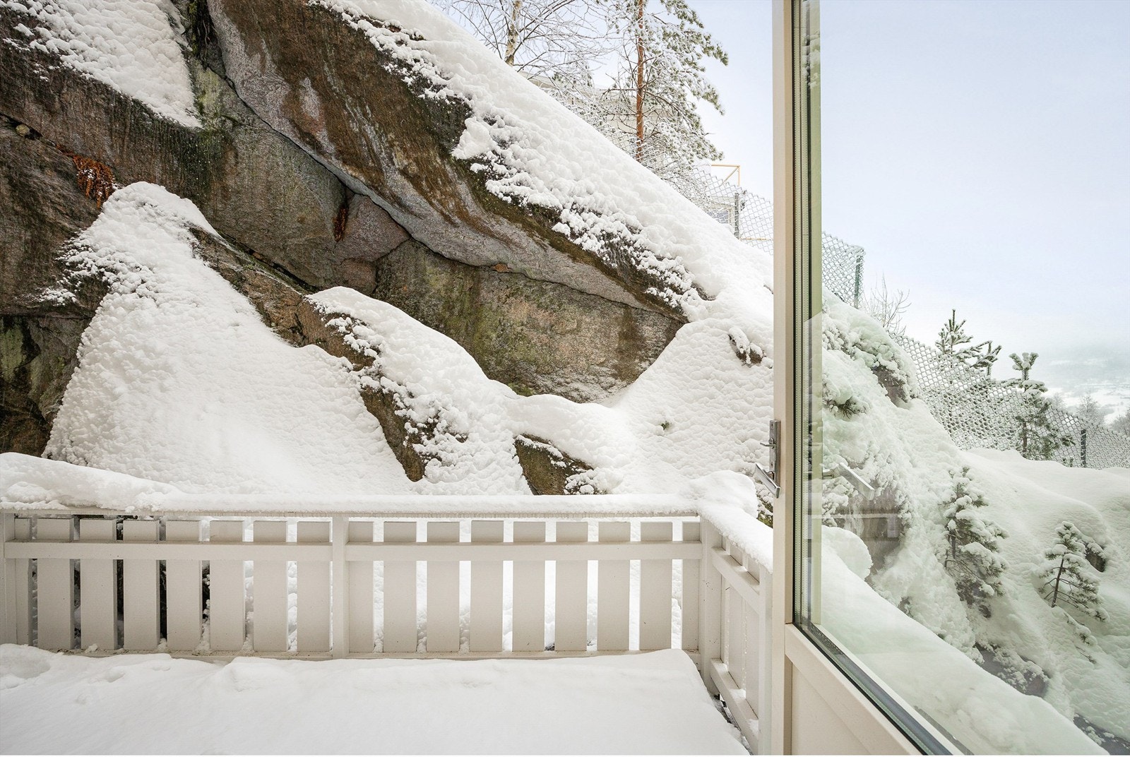 Lun nordøstvendt balkong på ca. 6 kvm med terrassebord av tre på gulv og rekkverk med glassfelt Galleribilde