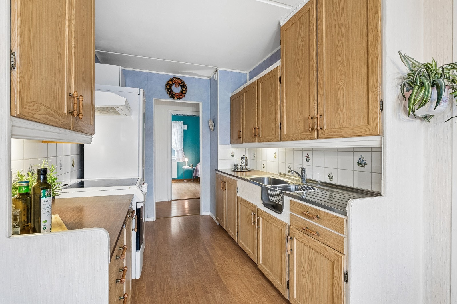 Kjøkkeninnredning med 1-speils profilerte fronter, originale skapskrog og laminat benkeplate med fliser over. Galleribilde