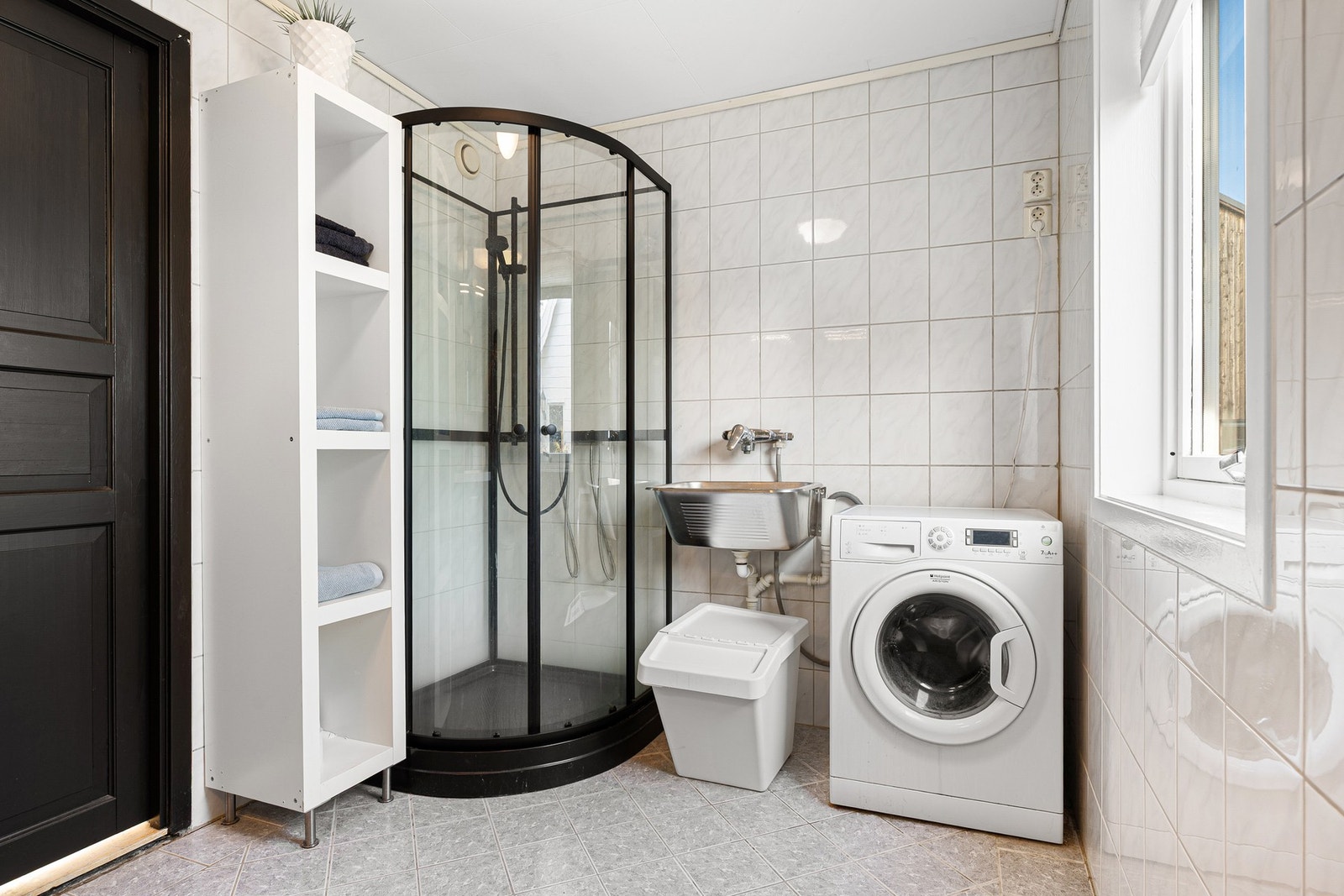 Det er utstyrt med servant, underskap, speilskap, vaskekar, dusjkabinett, og gulvmontert toalett. Galleribilde