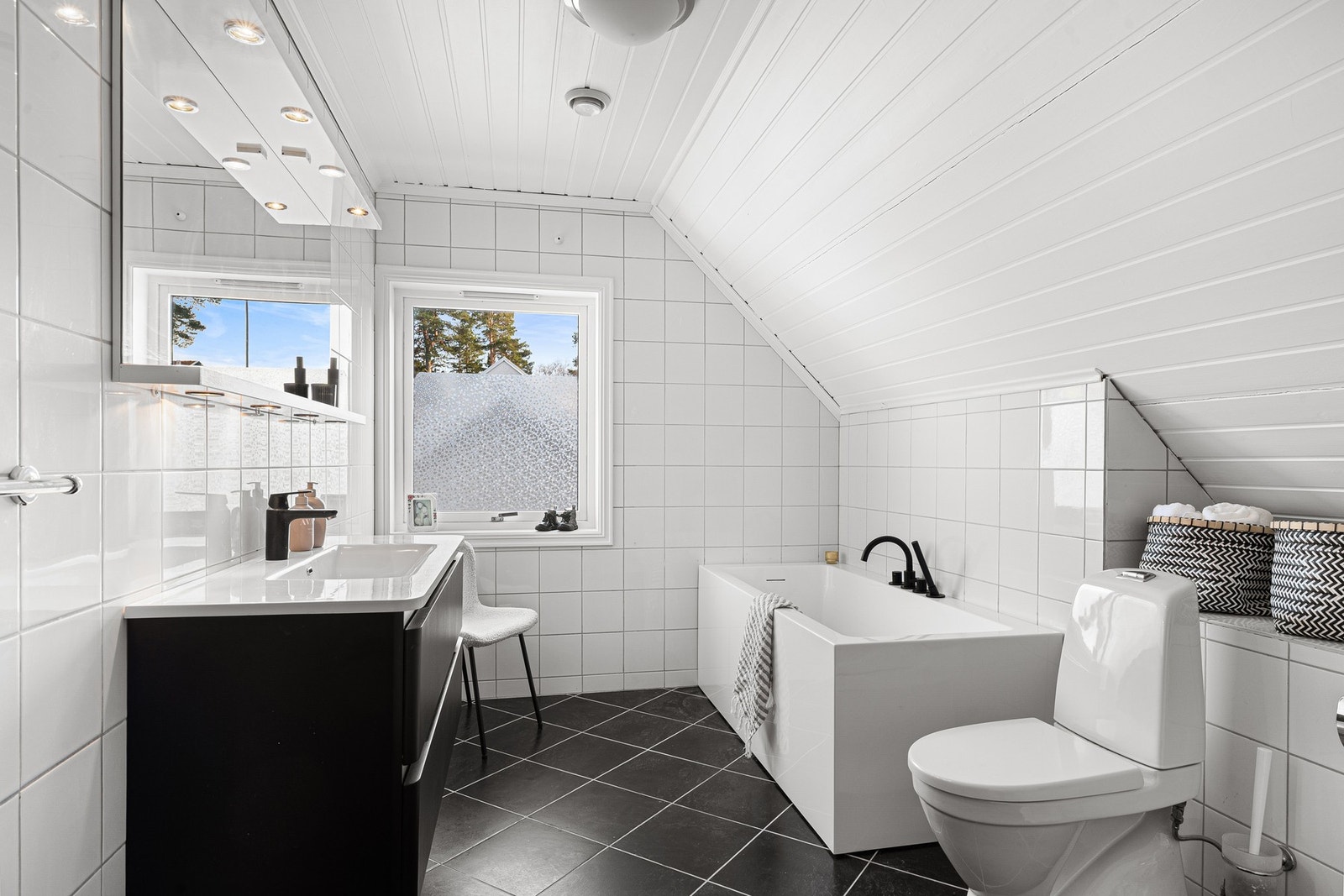 Rommet er utstyrt med servant, underskap, veggskap, speil, gulvmontert toalett, bidé og badekar. Galleribilde