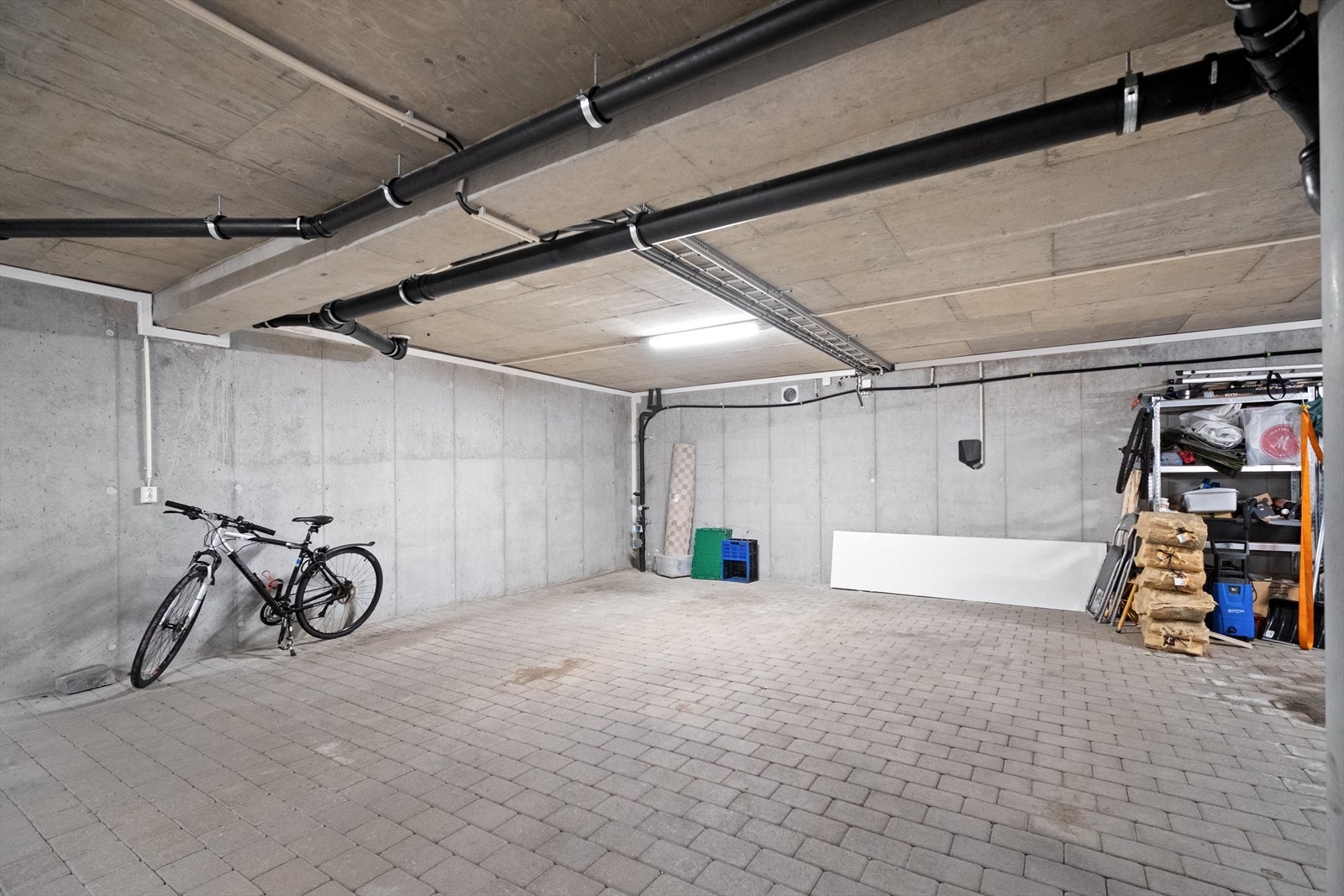 Garasje med betongvegger og god plass til parkering og lagring. Galleribilde