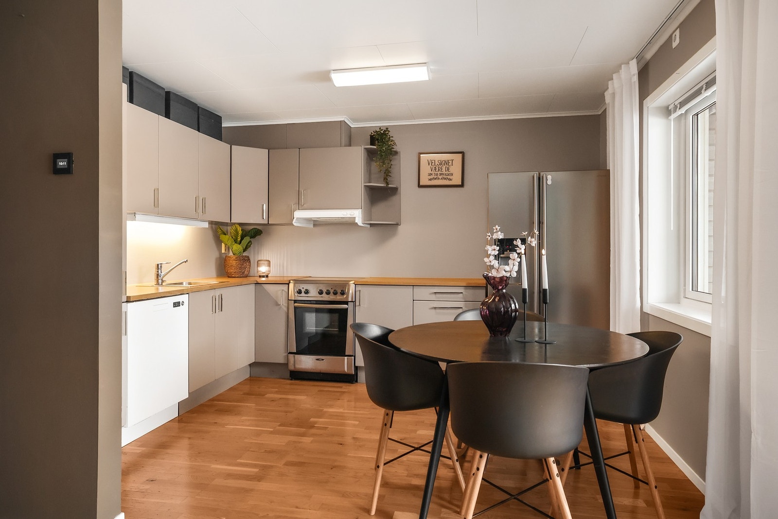 Åpen kjøkkenløsning med innredning med glatte fronter og benkeplate med laminert overflate. Galleribilde