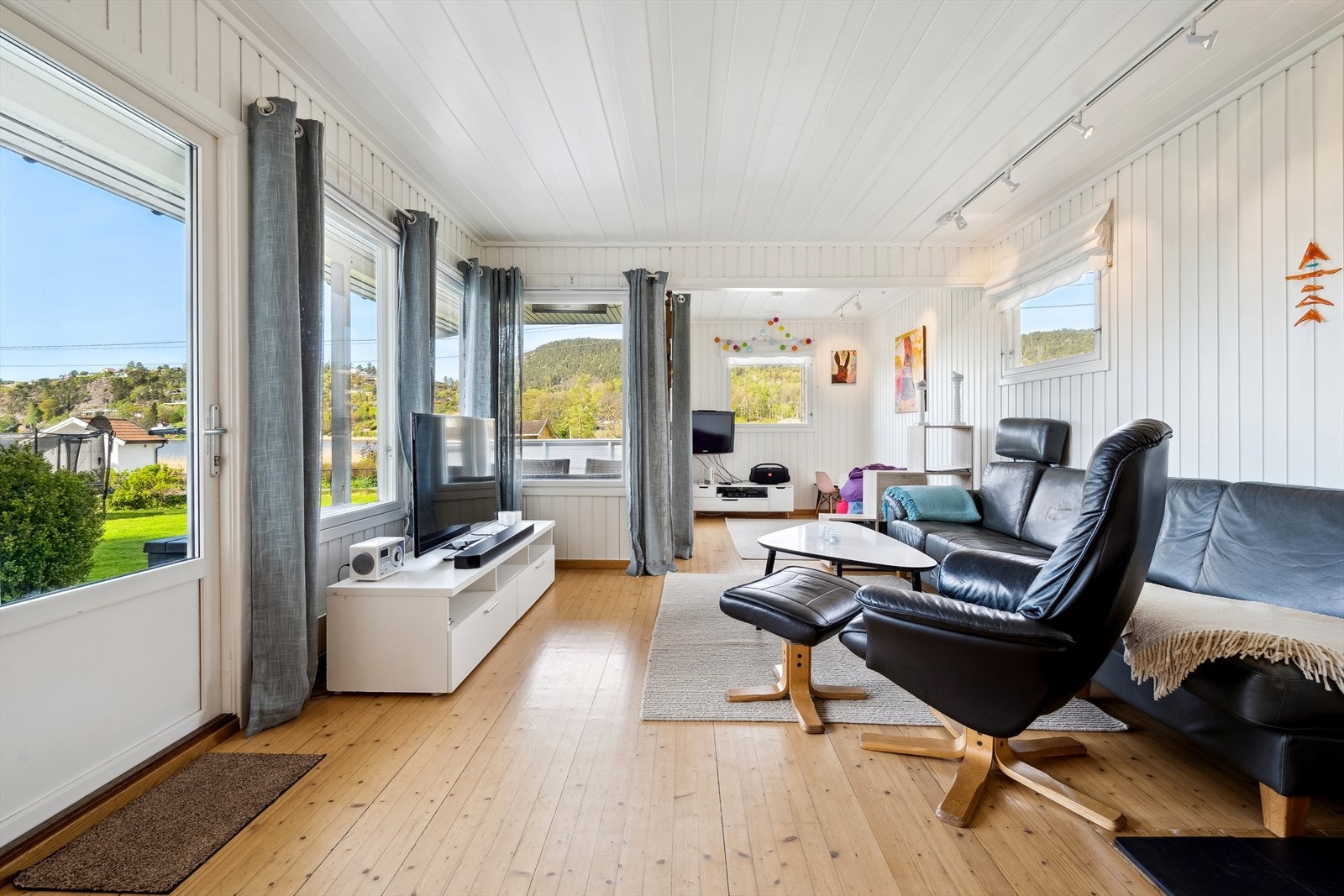 Stuen har store vindusflater som gir mye naturlig lysinnslipp og bidrar til en behagelig romfølelse. Galleribilde