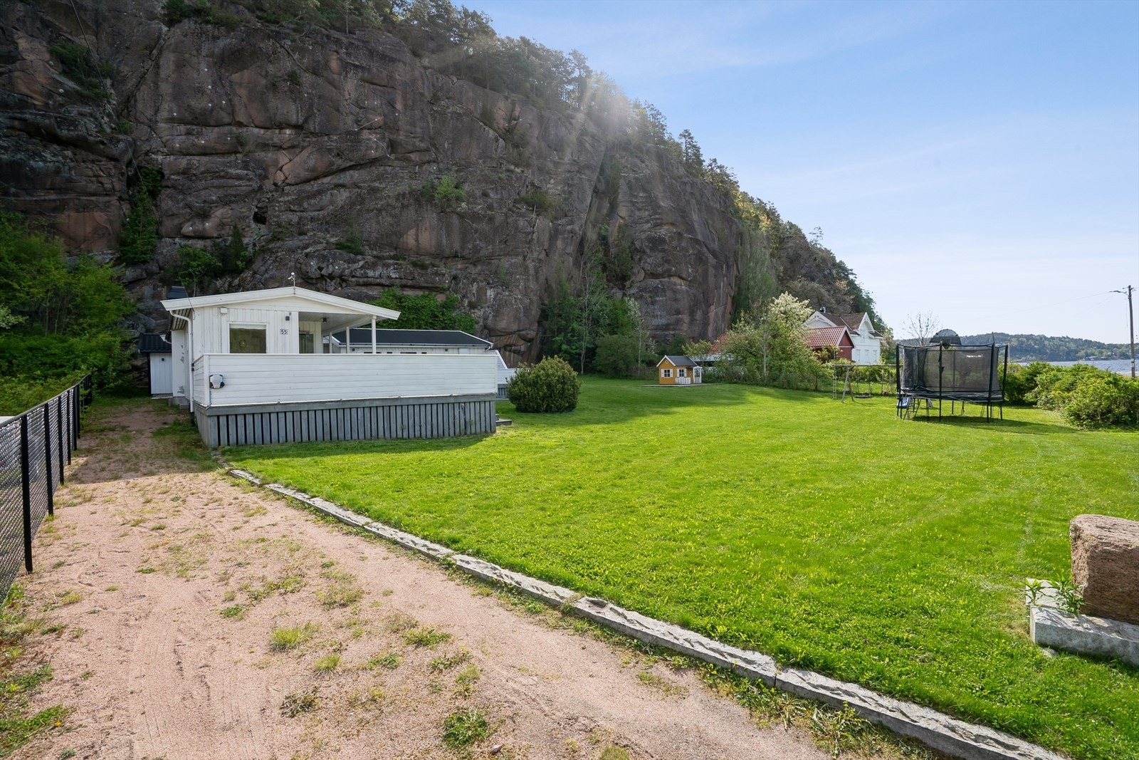 Stor eiendomstomt ( 1 570 m²) pent opparbeidet med gressplen, beplantning og prydbusker. Ypperlig for utendørs aktiviteter. Gruset gårdsplass. Galleribilde